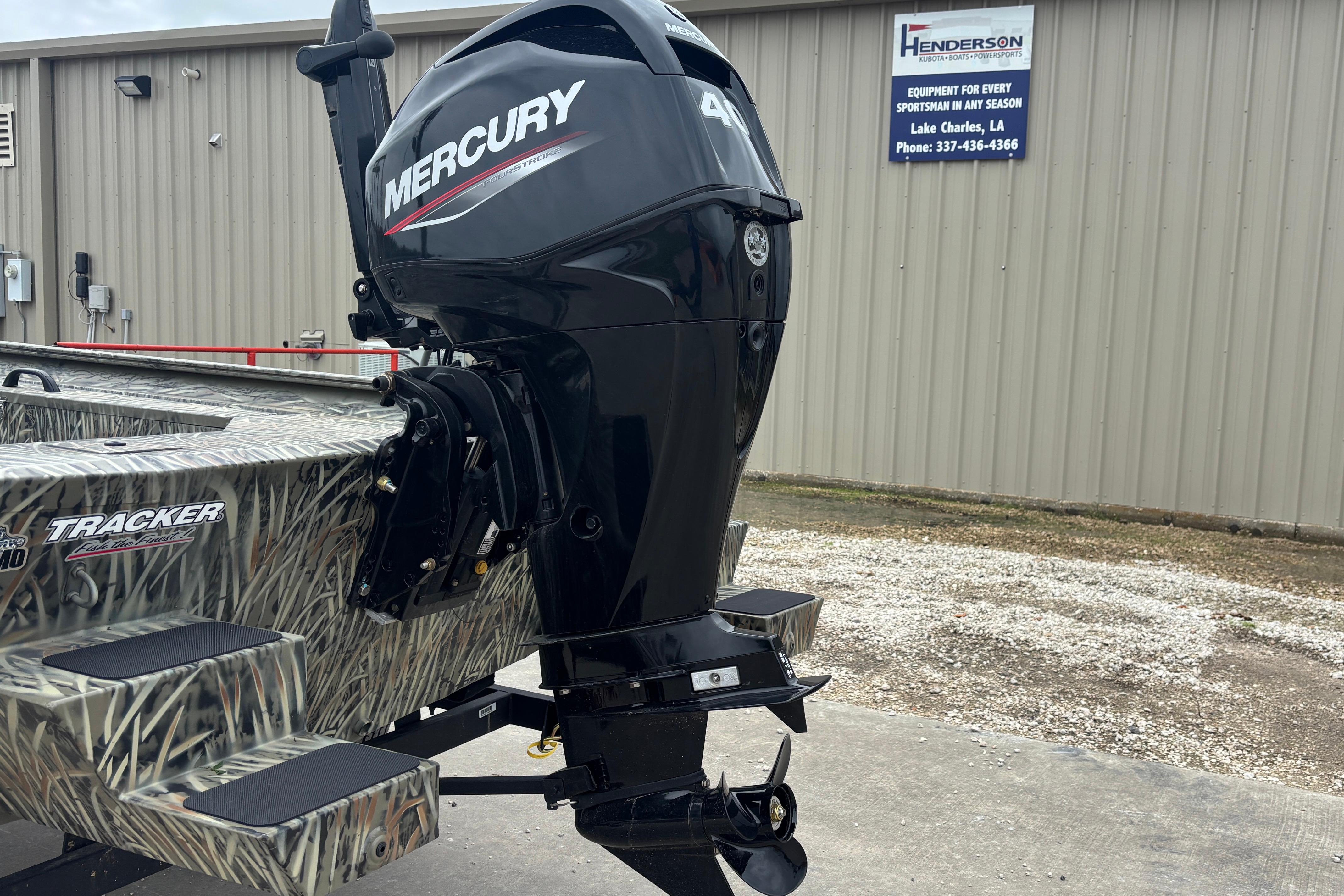2026 Tracker Grizzly 1654 T Sportsman boat with Mercury outboard motor, parked outside.