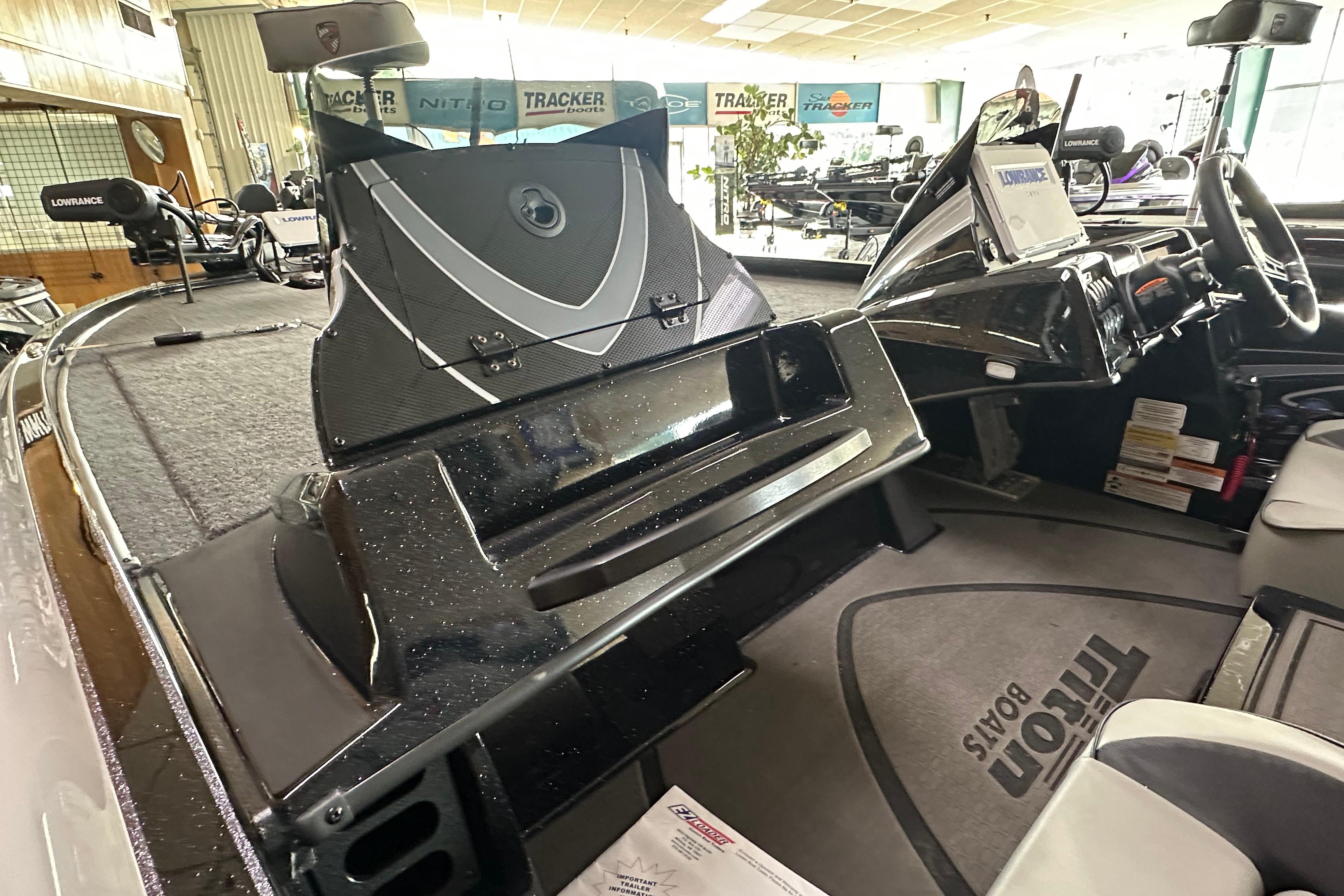 2024 Triton 20XP Patriot boat interior with advanced dashboard and seating in showroom.