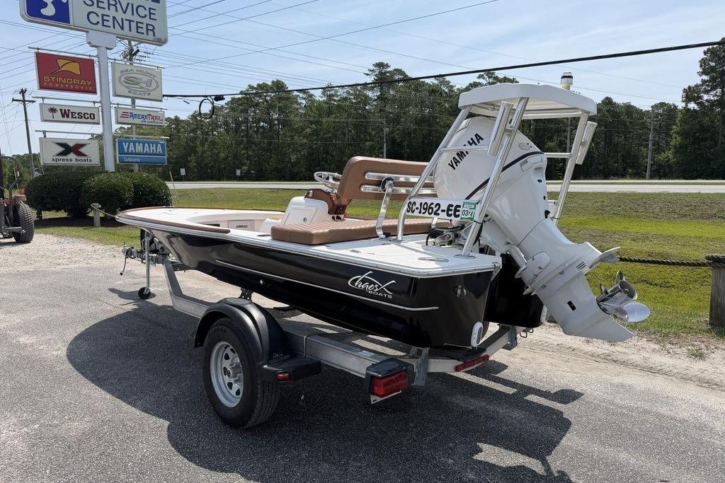 2012 Chaos 16 Bonefish boat on trailer, parked near service center signs.