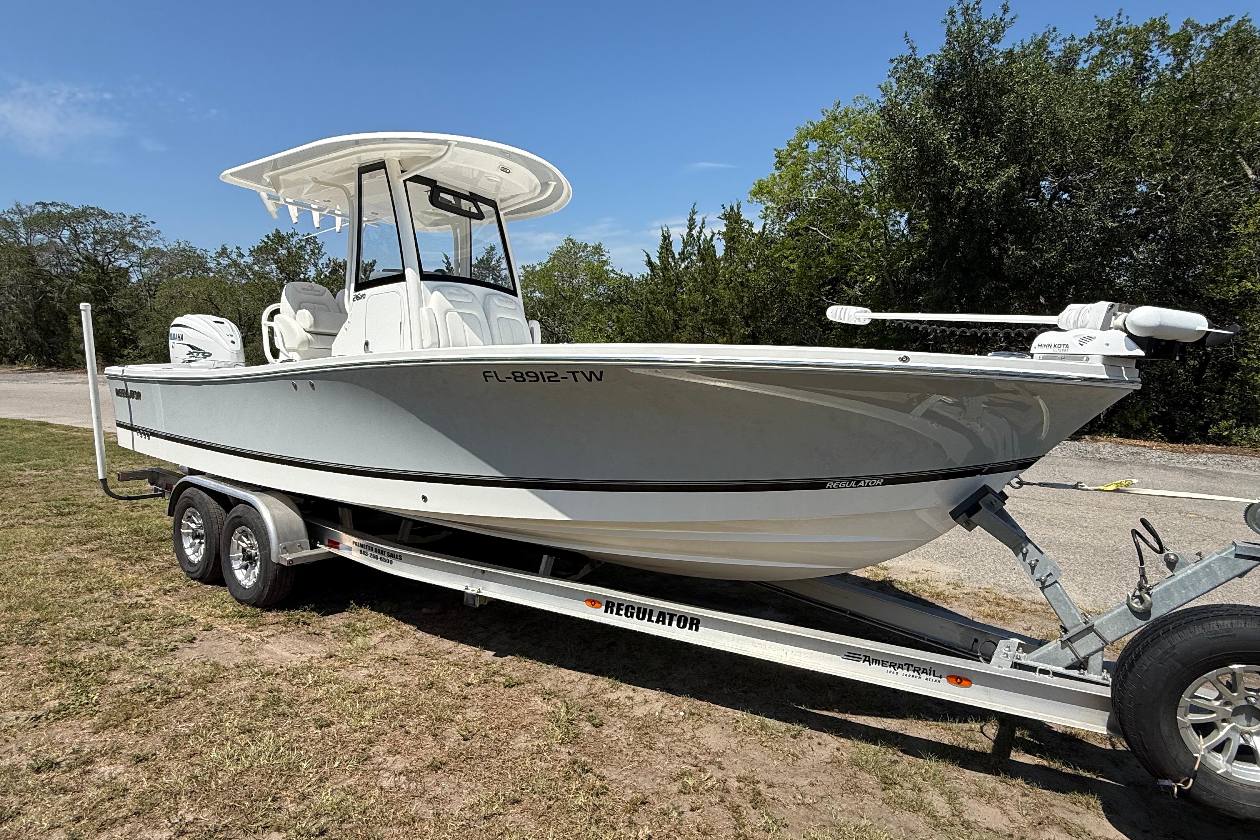 2023 Regulator 26XO boat on trailer, parked outdoors, side view.