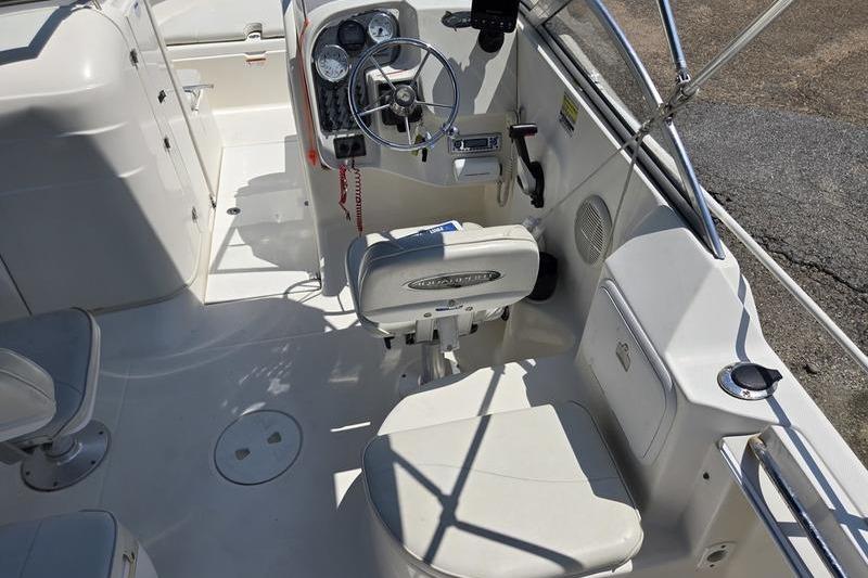 2004 Aquasport 215 Osprey Sport boat interior with steering wheel and seating.