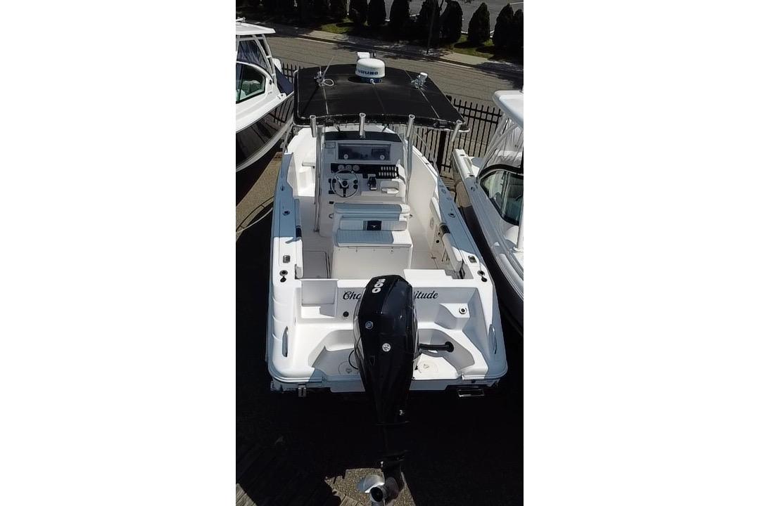 2002 Pro-Line 23 Sport boat with outboard motor, docked alongside other vessels.