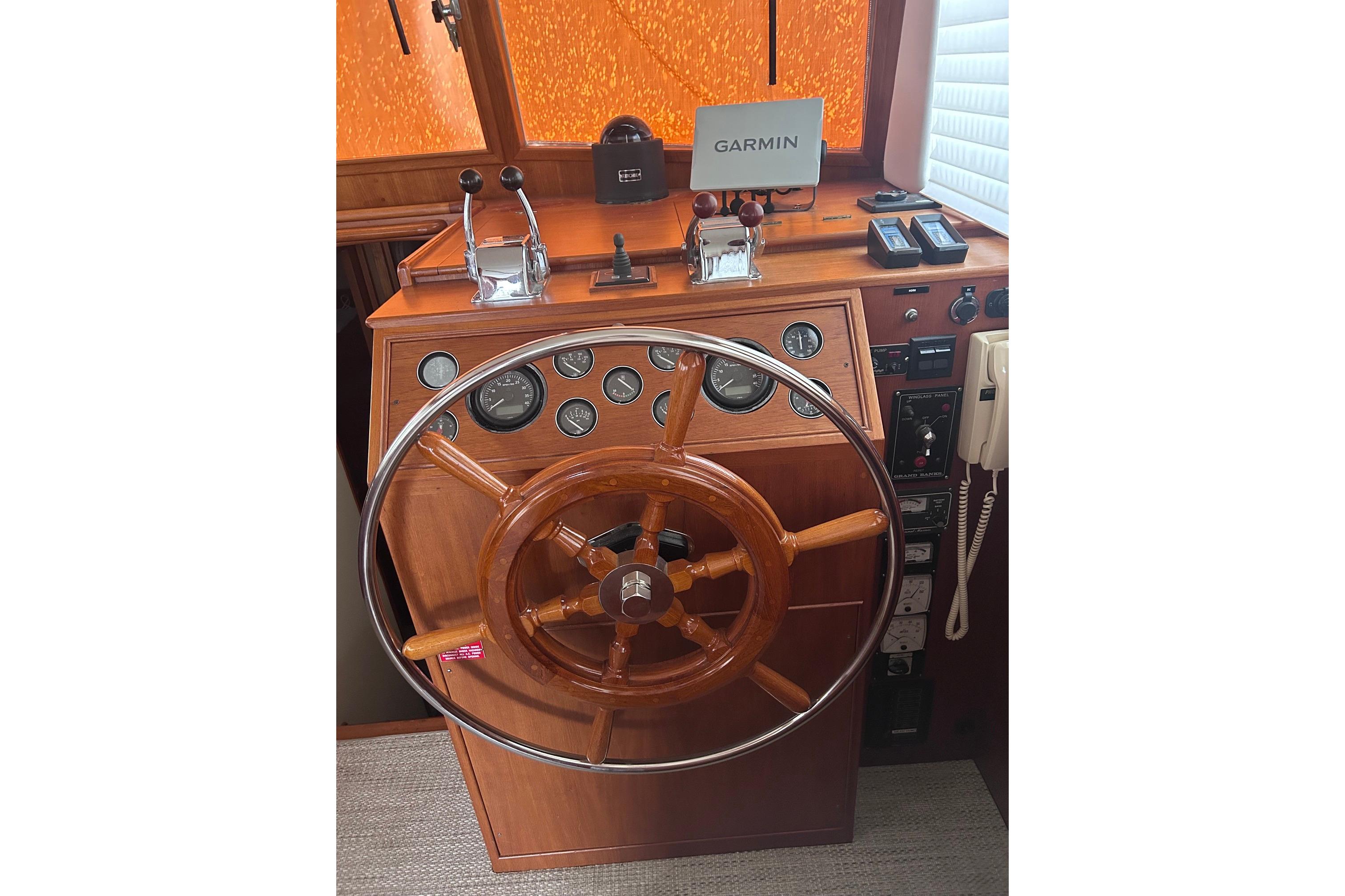 Helm of 1999 Grand Banks 42 Europa with wooden wheel and navigation instruments.