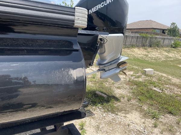 2023 Regency 250 DL3 boat with Mercury outboard motor, parked on grassy area.