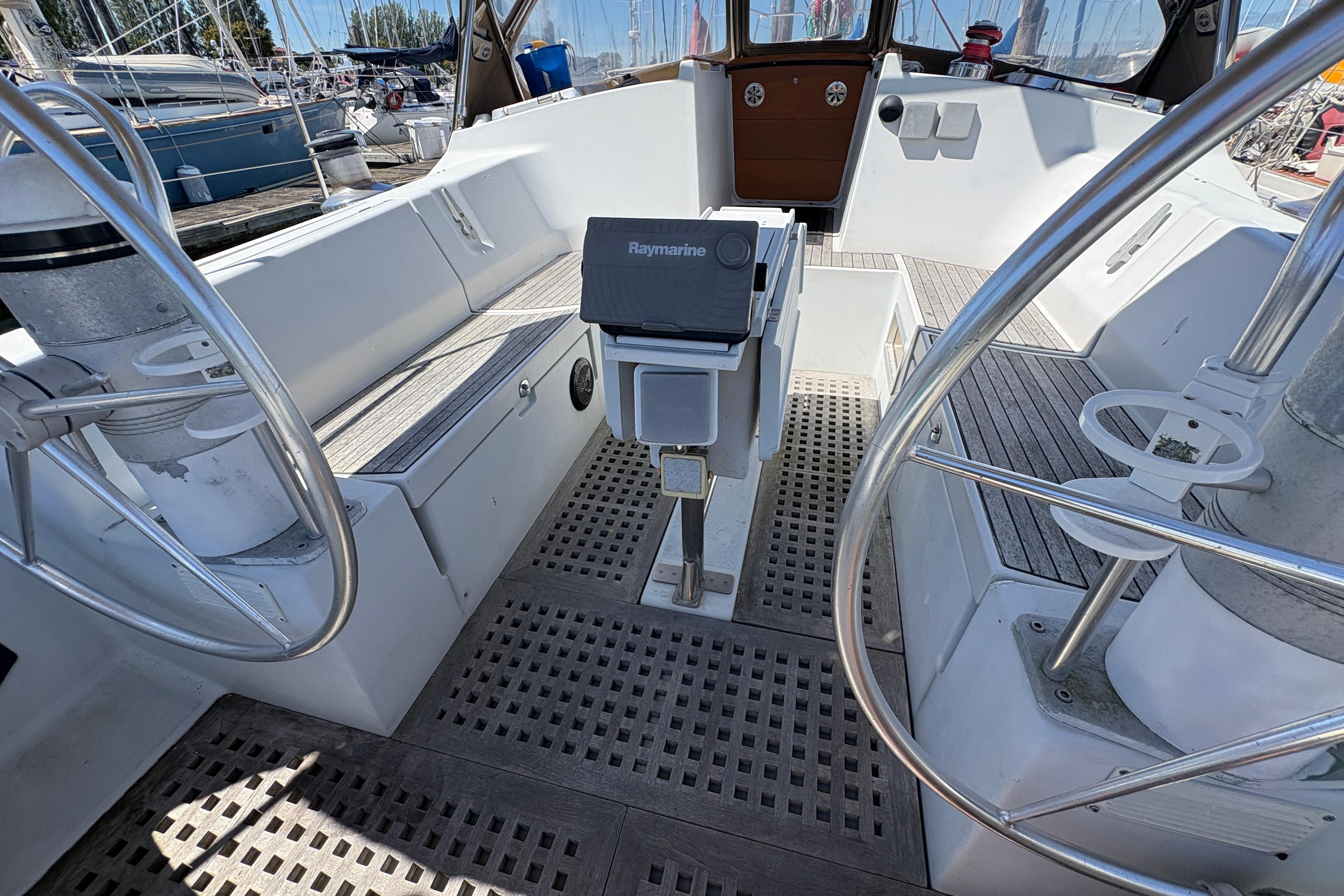 1990 Beneteau Oceanis 500 yacht cockpit with dual steering wheels and Raymarine equipment.