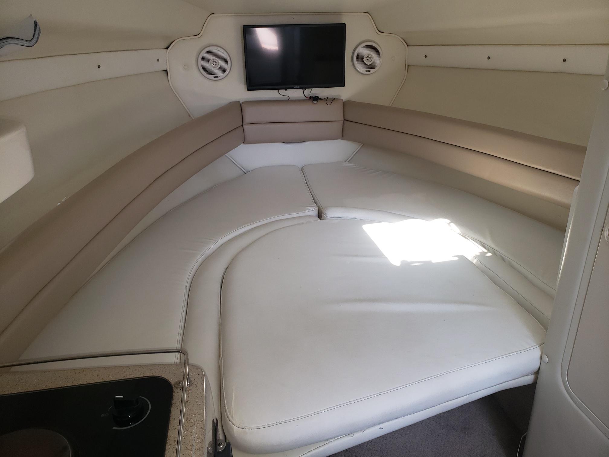 1999 Rinker Fiesta Vee cabin interior with bed, TV, and speakers.