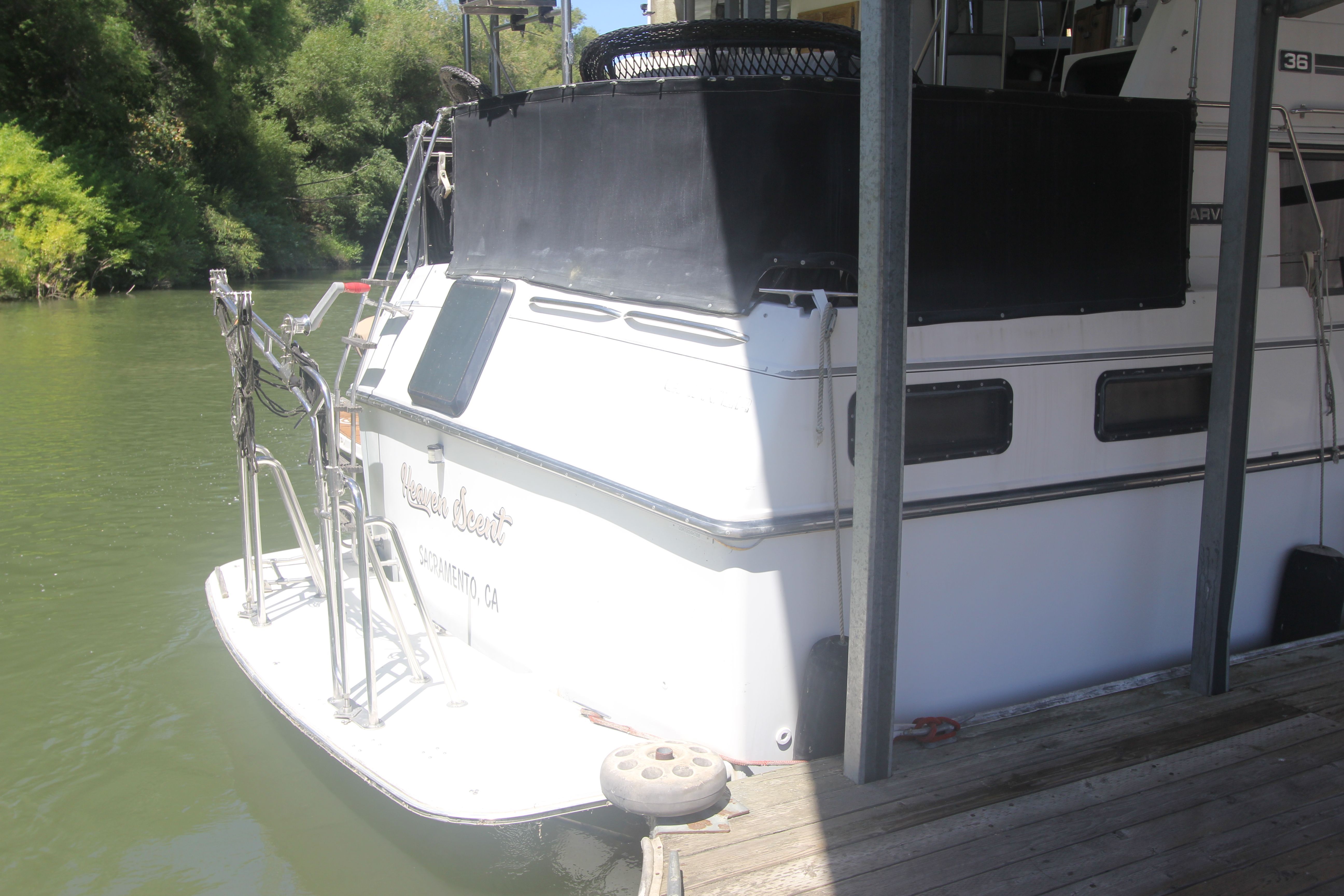 A 1988 Carver 3607 Aft Cabin Motor Yacht docked at a calm riverside.