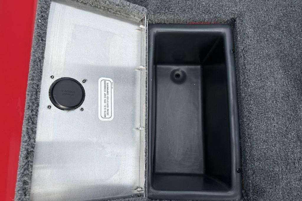 Open storage compartment in 2026 Tracker Pro Team 175 boat, featuring carpeted interior.