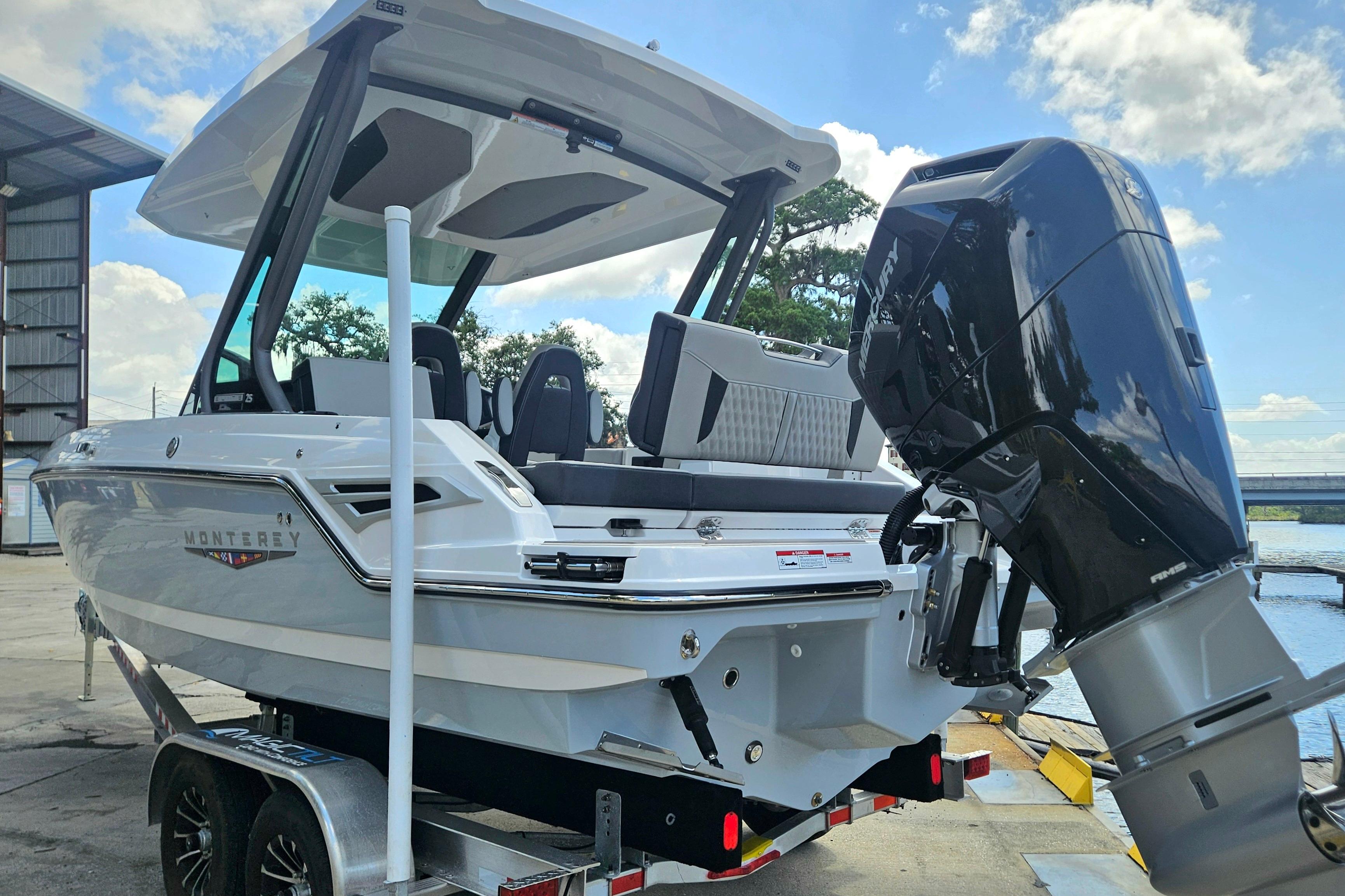 2026 Monterey Elite 25 OB boat with powerful outboard motor, docked near water.