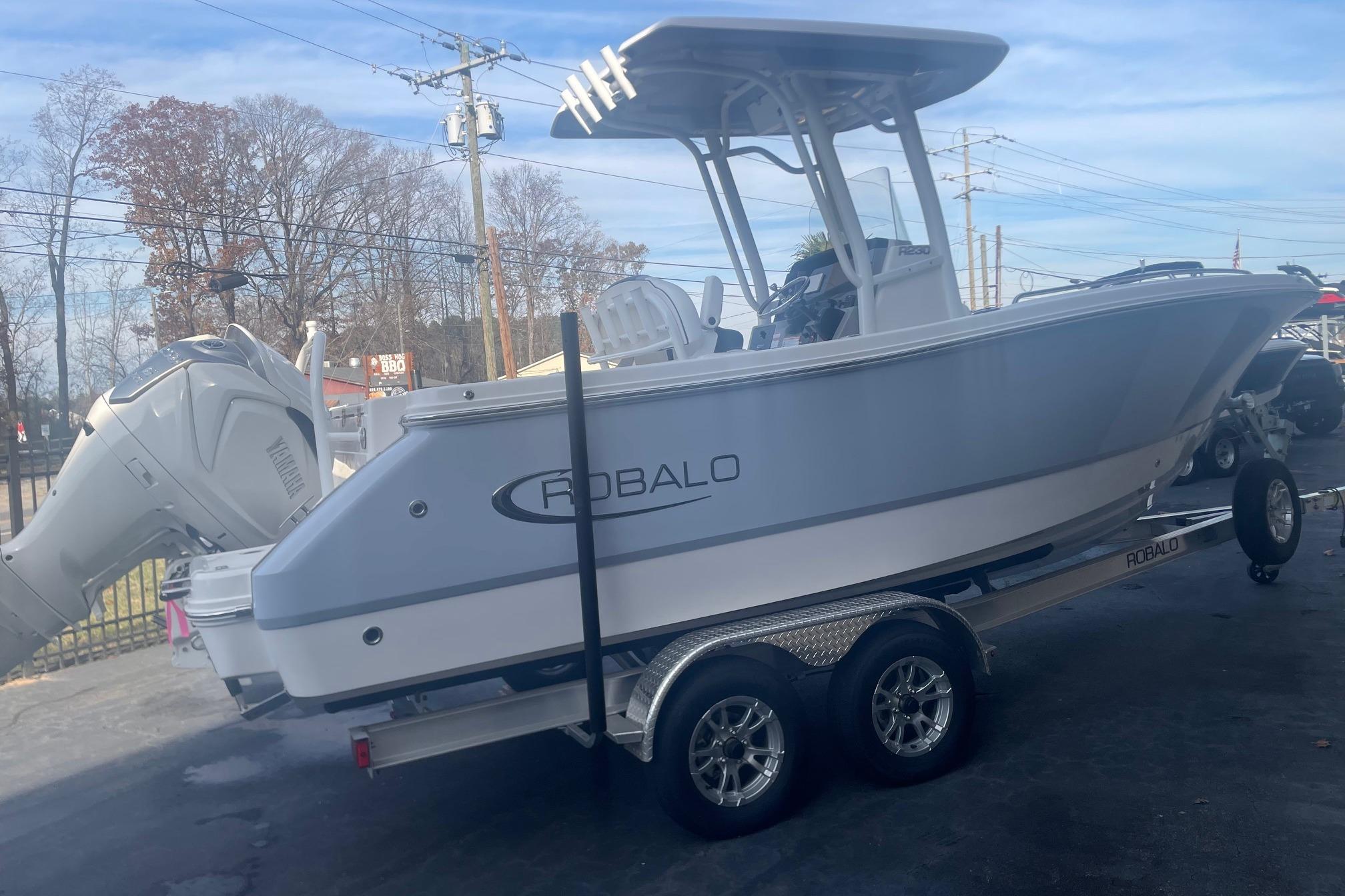 2024 Robalo R230 Center Console boat on trailer, featuring sleek design and powerful engine.