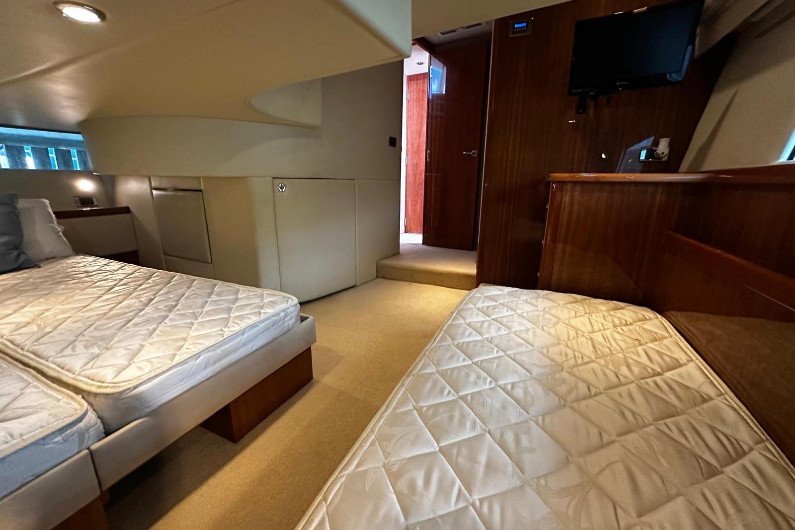 Interior of 2012 Riviera 43 Flybridge yacht with twin beds and modern amenities.