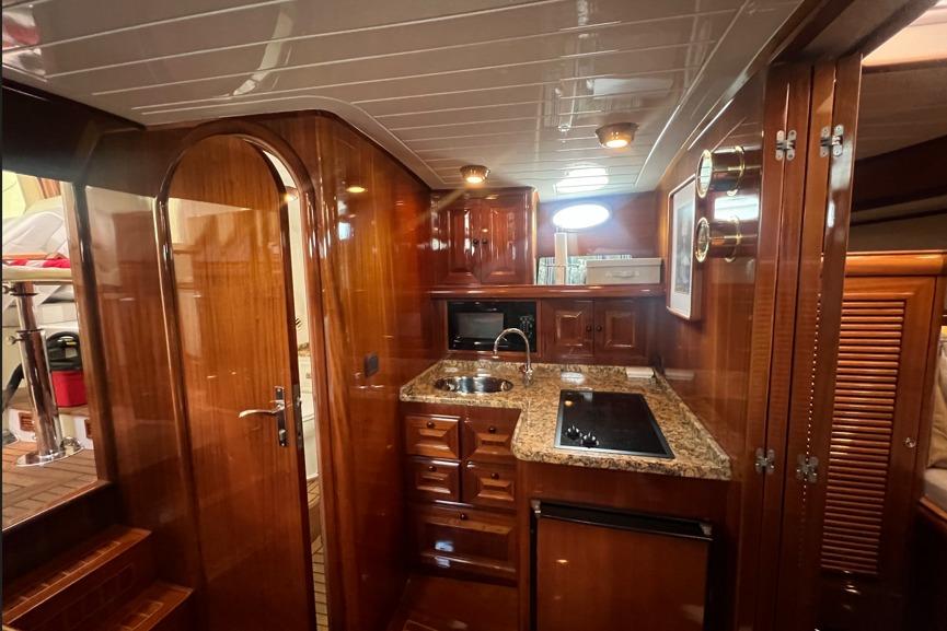 Luxurious wooden interior of 2004 RB DERELI Daytripper 40 yacht kitchen with granite countertops.