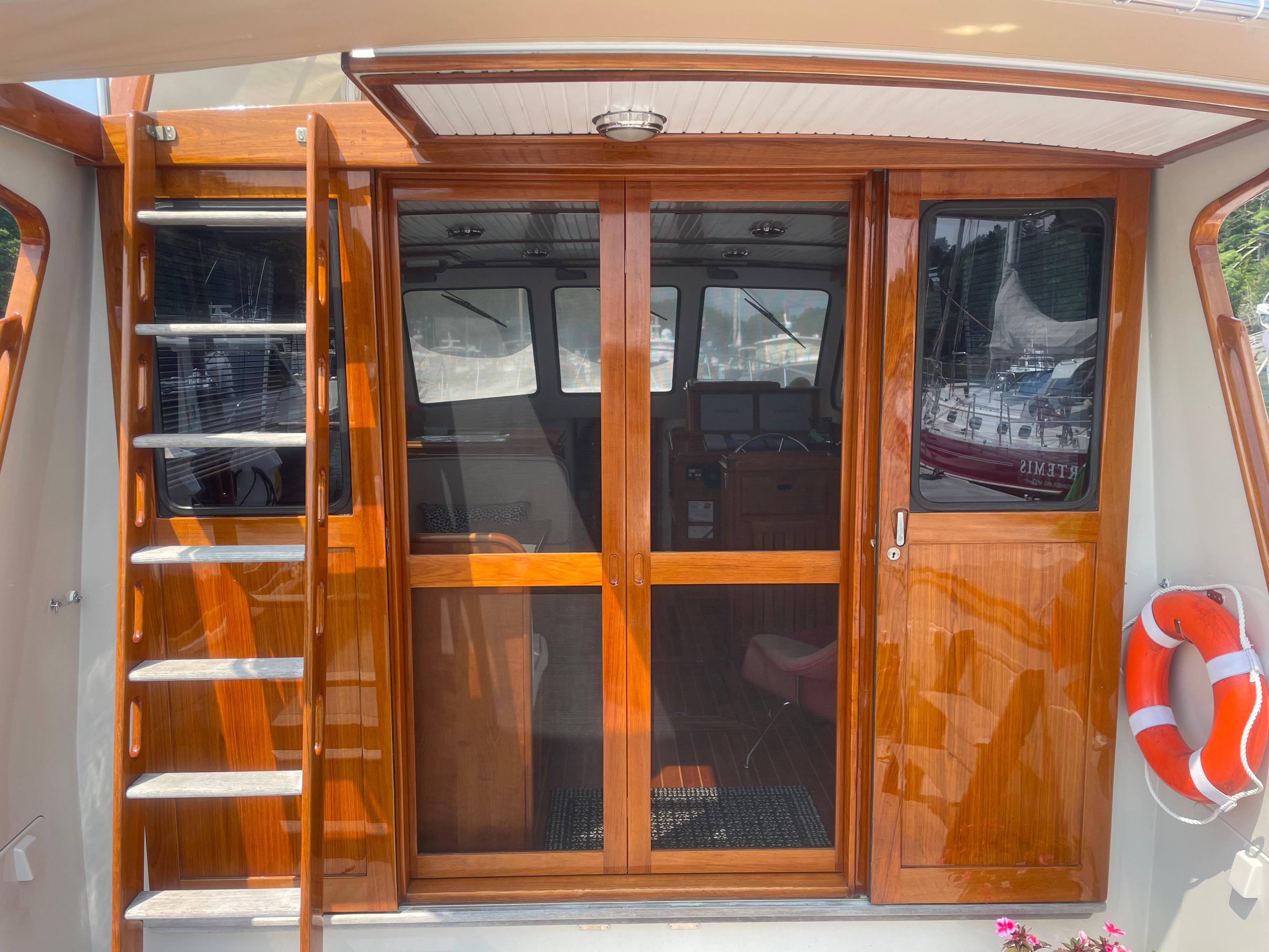 1997 Lyman-Morse Custom Flybridge yacht with wooden sliding doors and ladder.