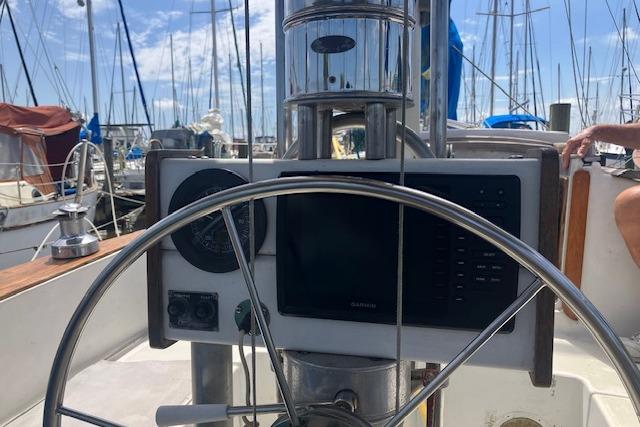 Steering wheel and navigation equipment on a 1979 Pearson 365 Ketch sailboat.