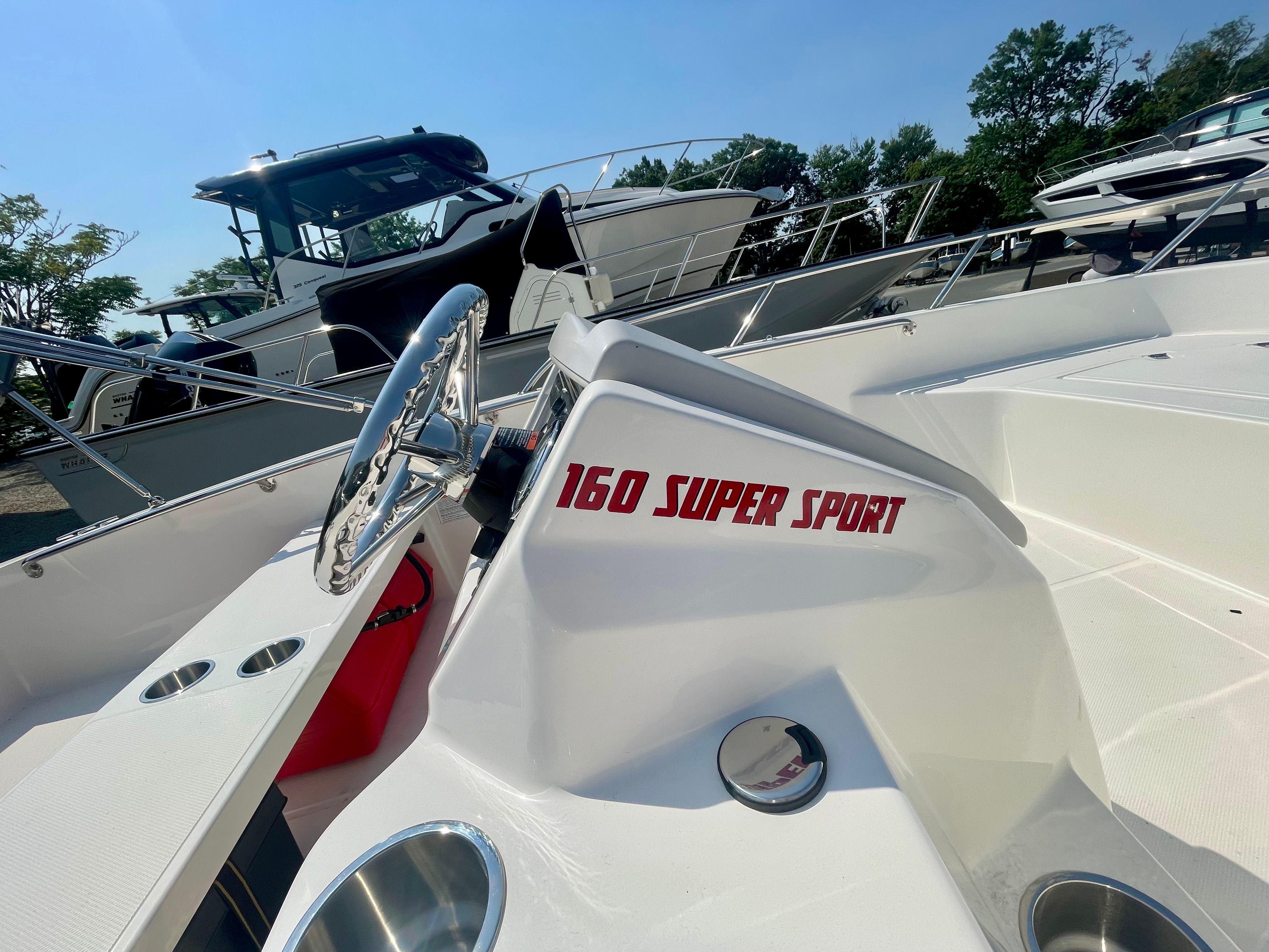 Close-up of a Boston Whaler 160 Super Sport helm with a shiny steering wheel.