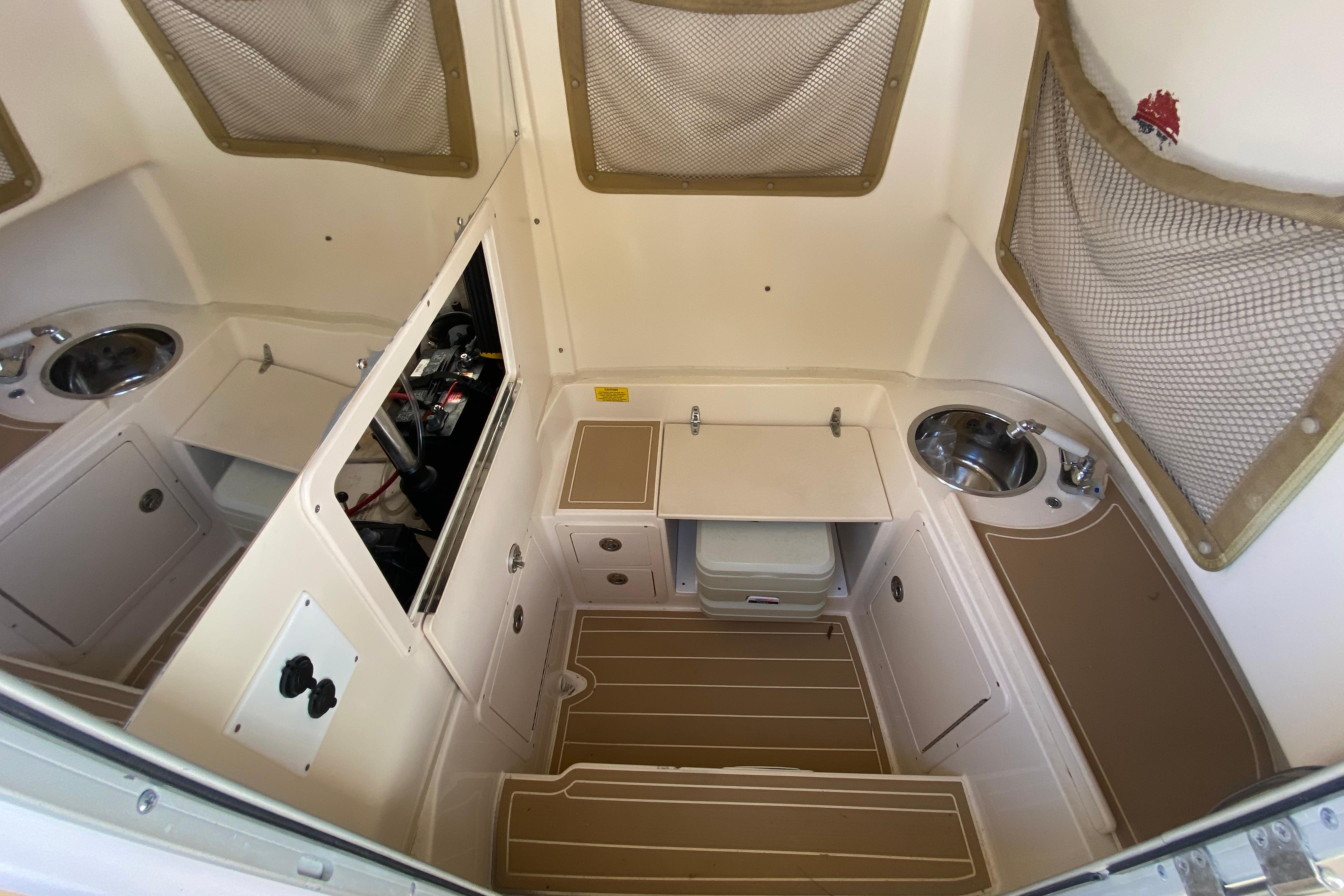2004 Grady-White Canyon 283 cabin interior with sink, storage, and compact design.