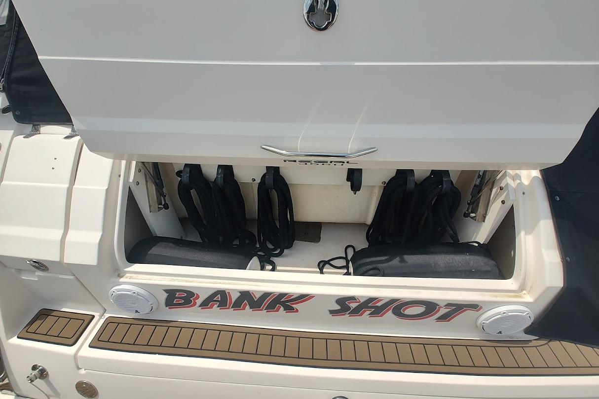 2006 Regal Commodore 3560 IO boat with open storage compartment labeled "Bank Shot."