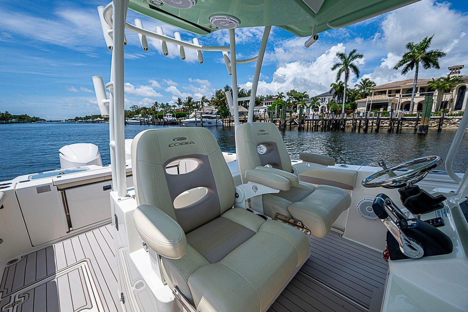 2019 Cobia 320 Center Console boat interior with luxurious seating and scenic waterfront view.