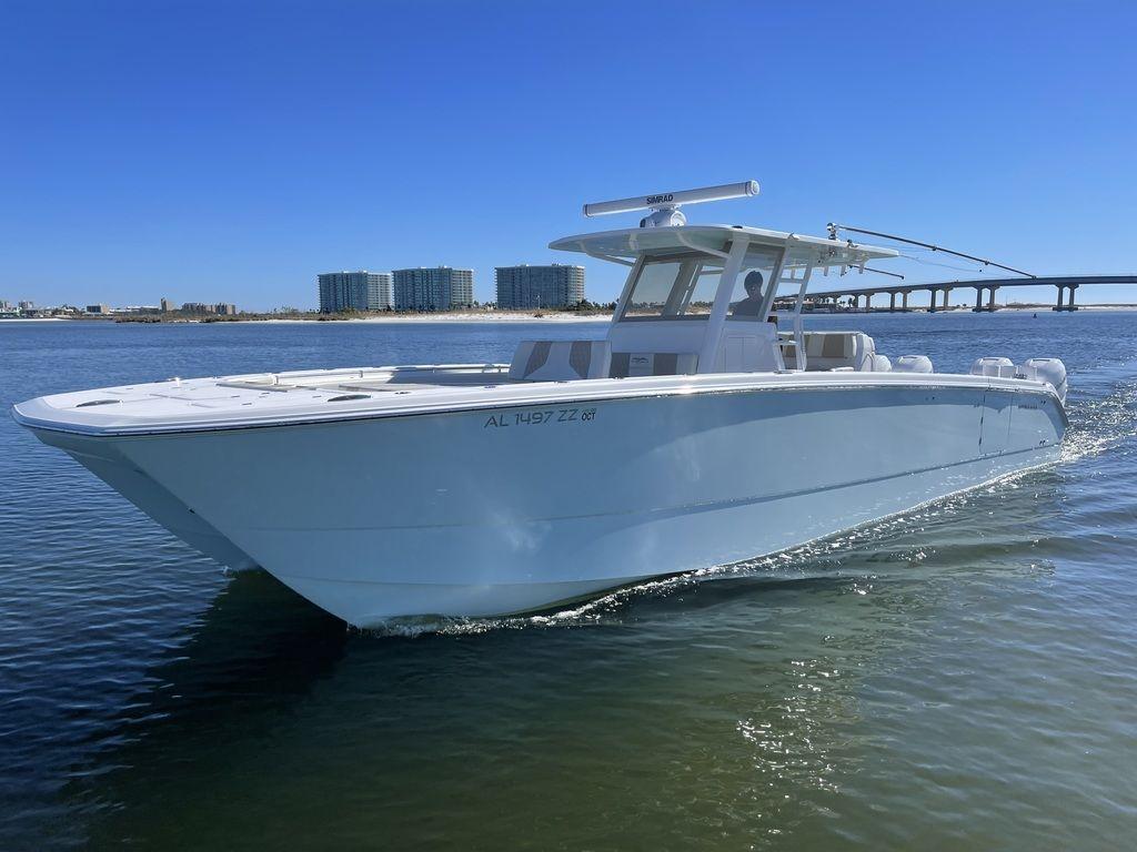 2019 Invincible 40 Catamaran cruising on calm waters near a bridge and buildings.