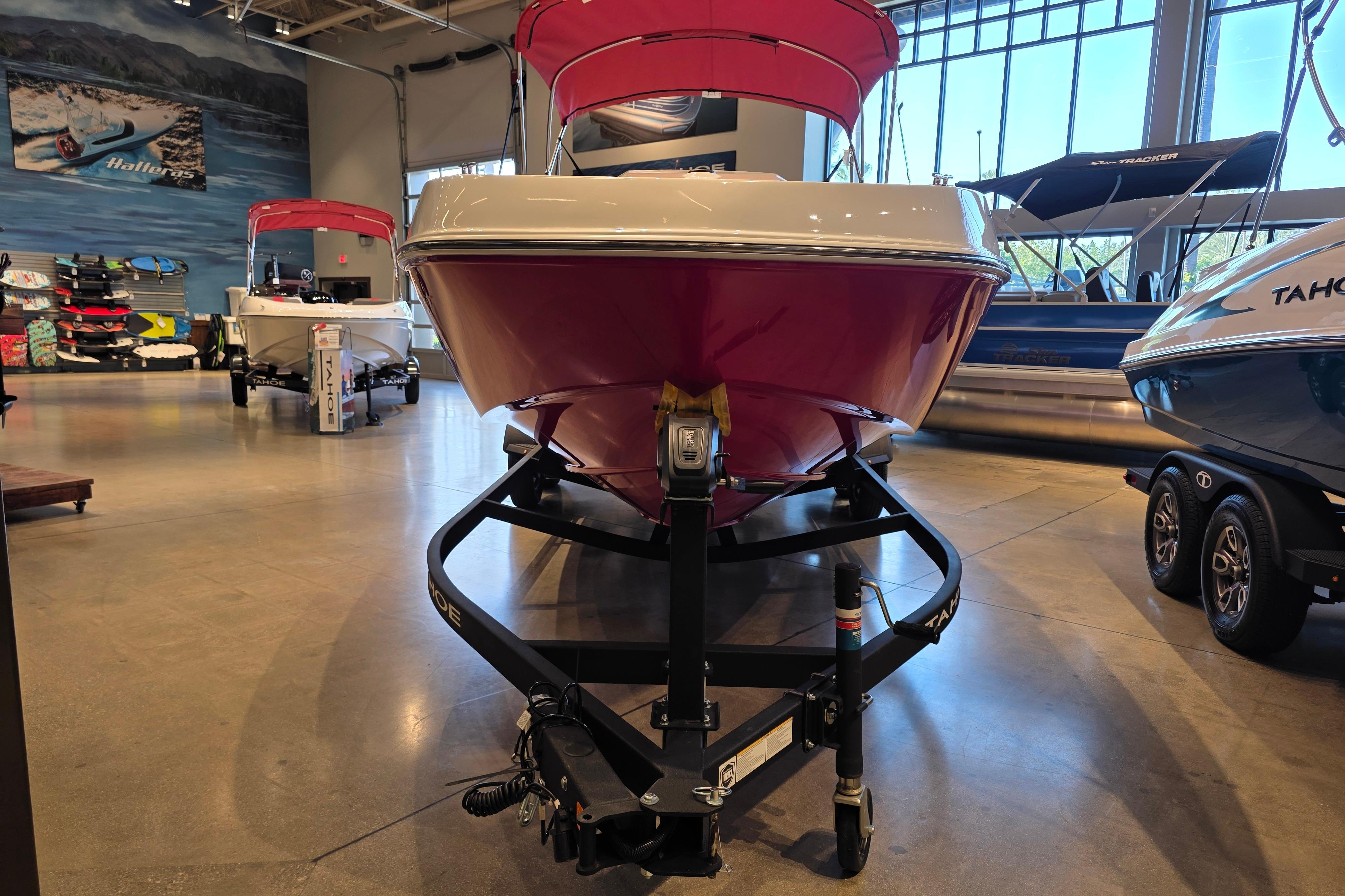 2026 Tahoe T21 boat displayed in showroom, featuring sleek red and white design.
