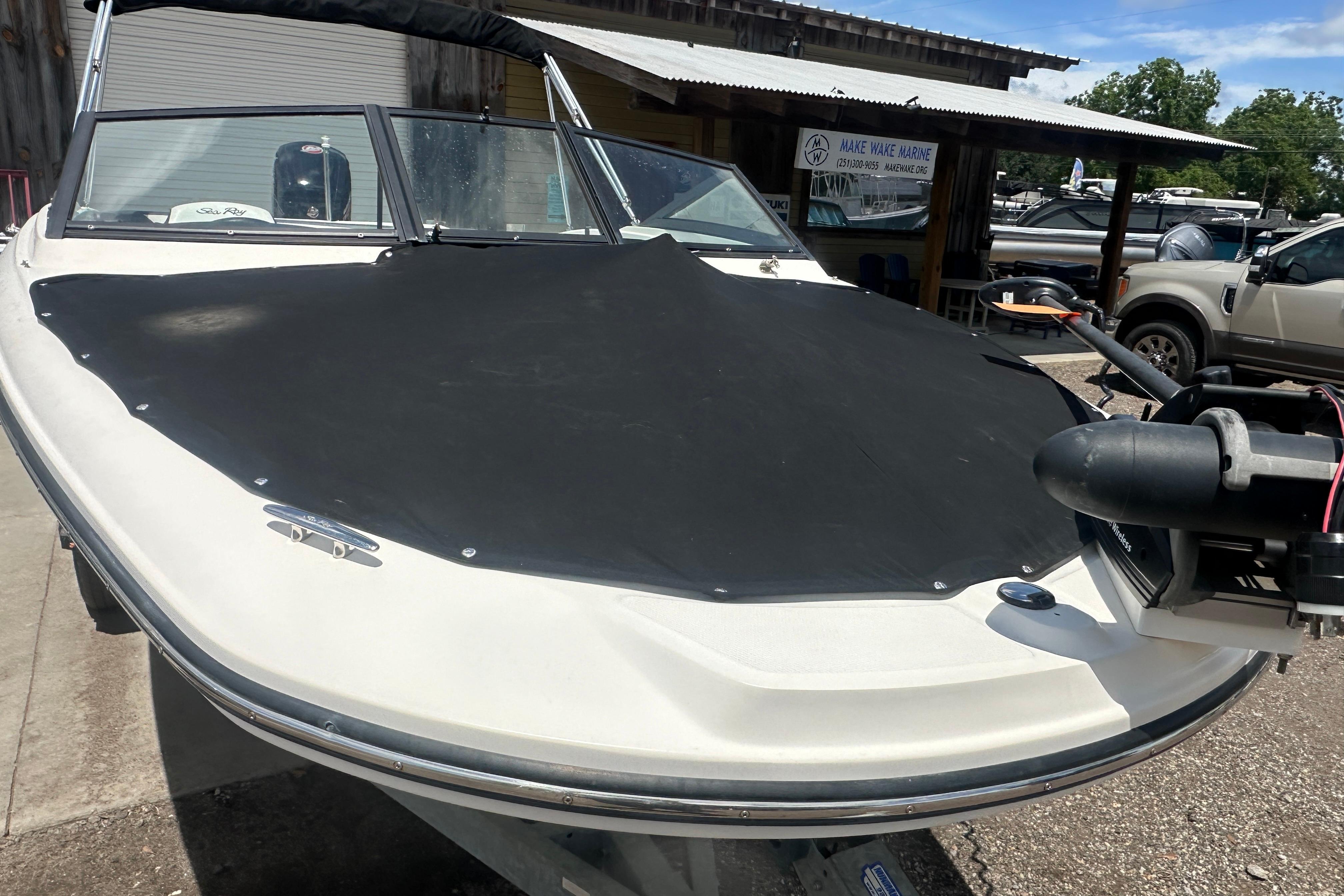 2017 Sea Ray SPX 190 Outboard boat with black cover, parked at a marina.