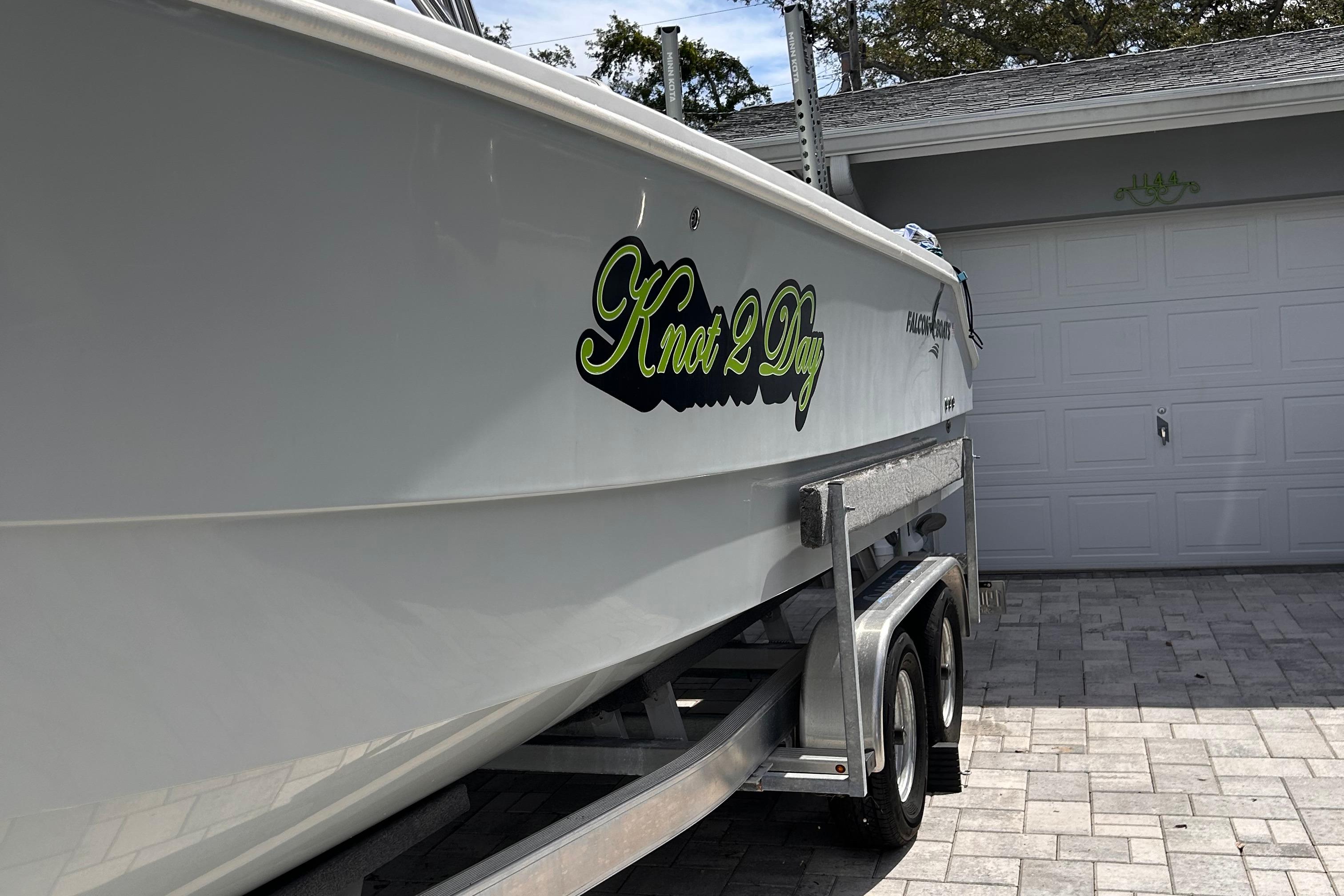2023 Falcon Boats F22 on trailer, featuring "Knot 2 Day" decal, parked in driveway.