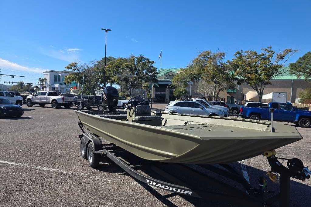 2026 Tracker Grizzly 2072 CC boat on trailer in parking lot, surrounded by vehicles.