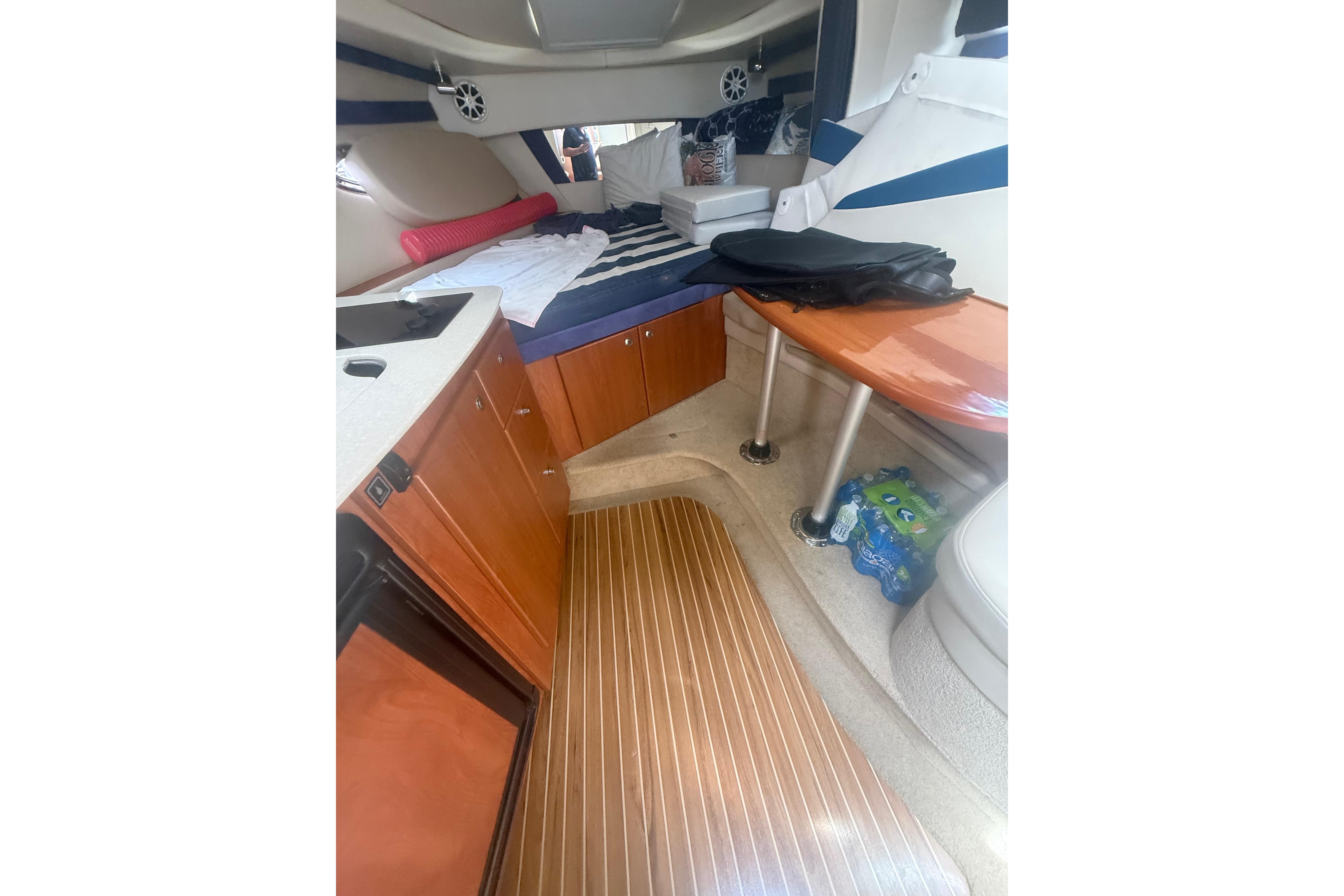 2008 Bayliner 320 cabin interior with wood flooring, kitchenette, and cozy seating area.