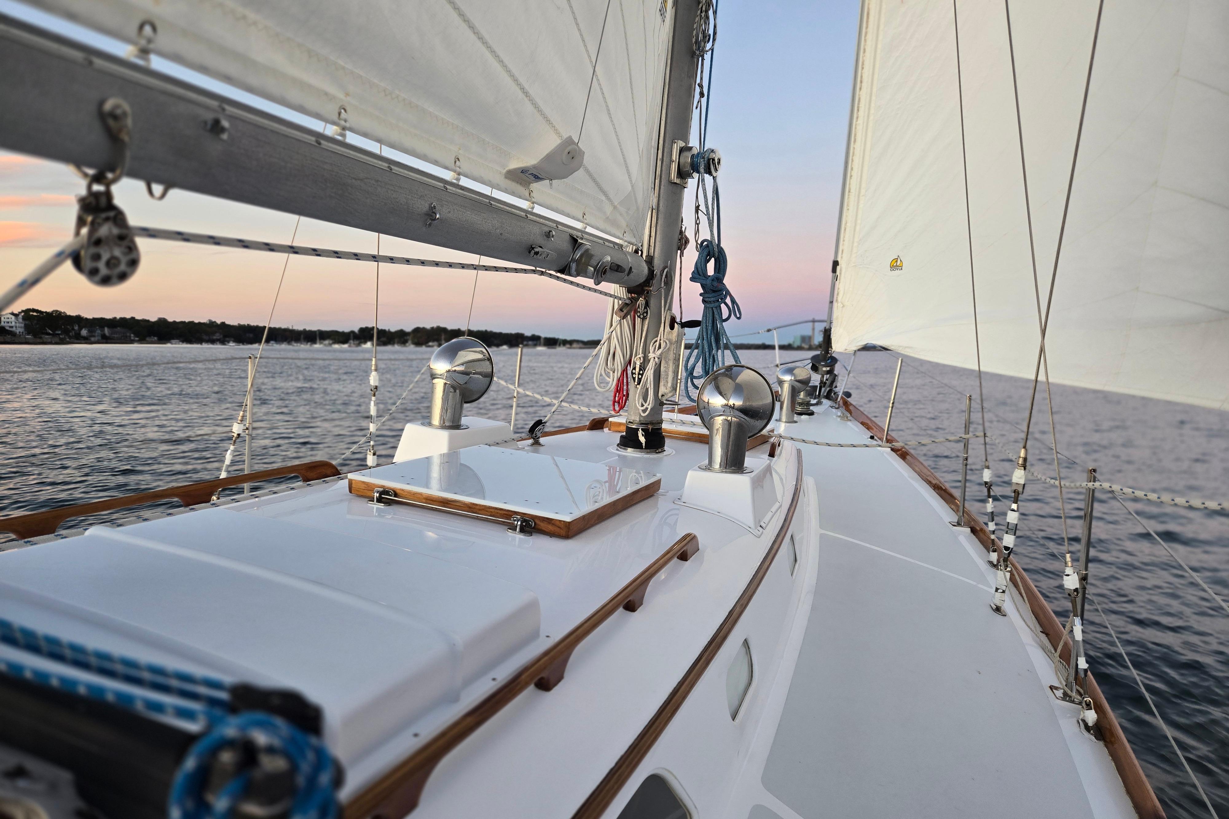 Sailing on a 1970 Hinckley Bermuda 40 yacht at sunset, showcasing elegant deck design.