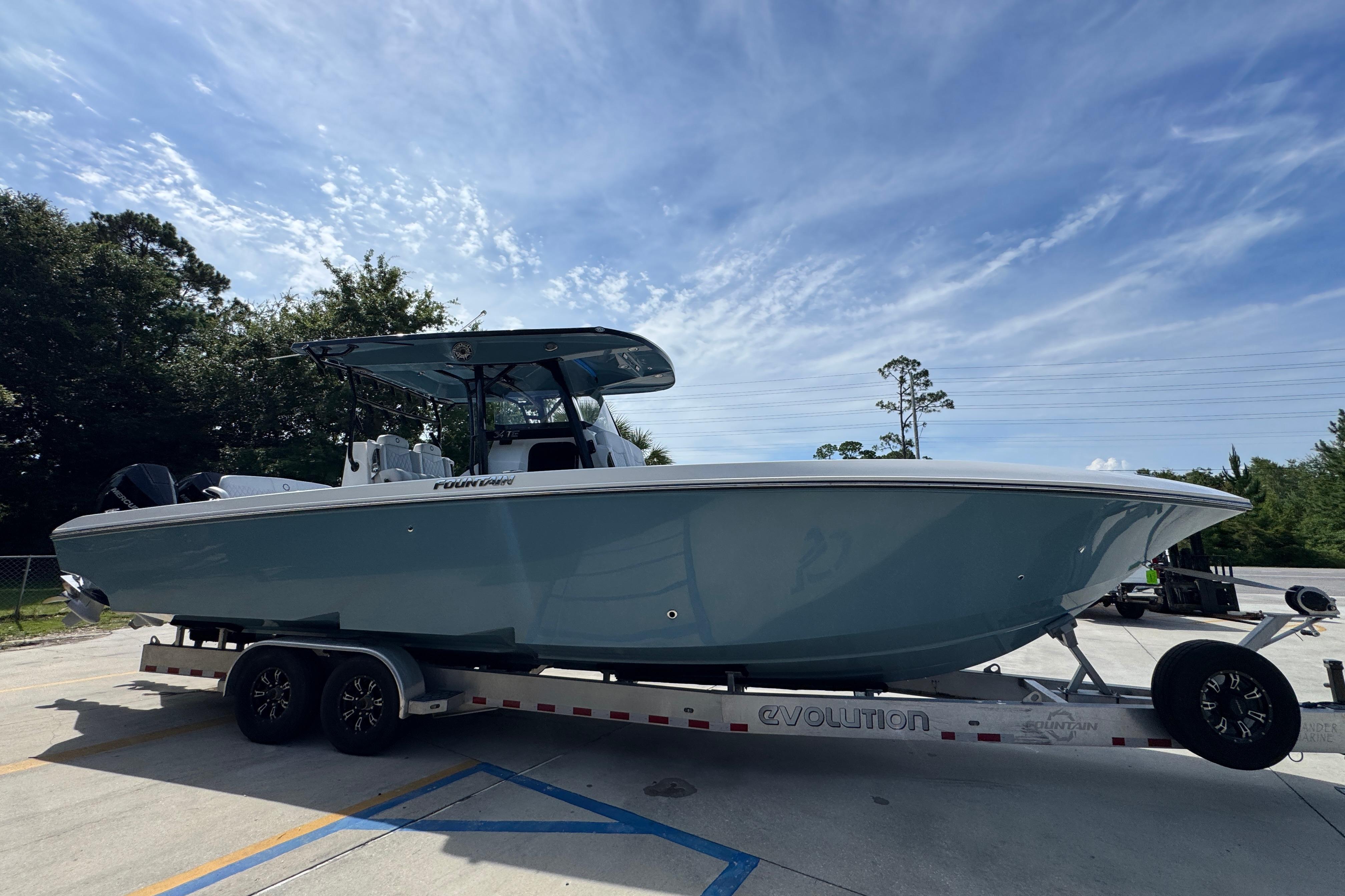 2023 Fountain 34 Tournament Edition boat on trailer under blue sky.