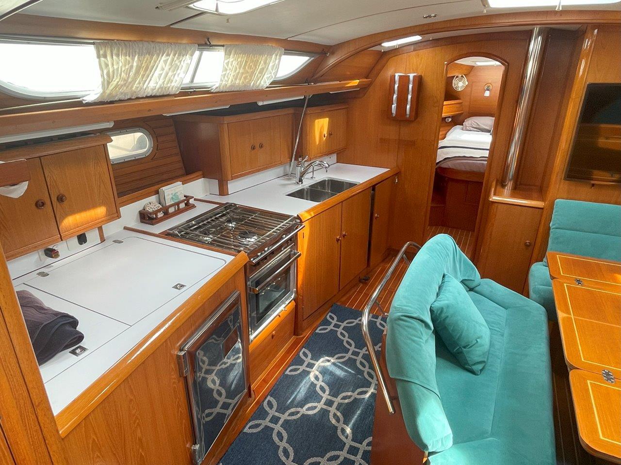 Interior of 1998 Jeanneau Sun Odyssey 45.2 yacht with kitchen and seating area.