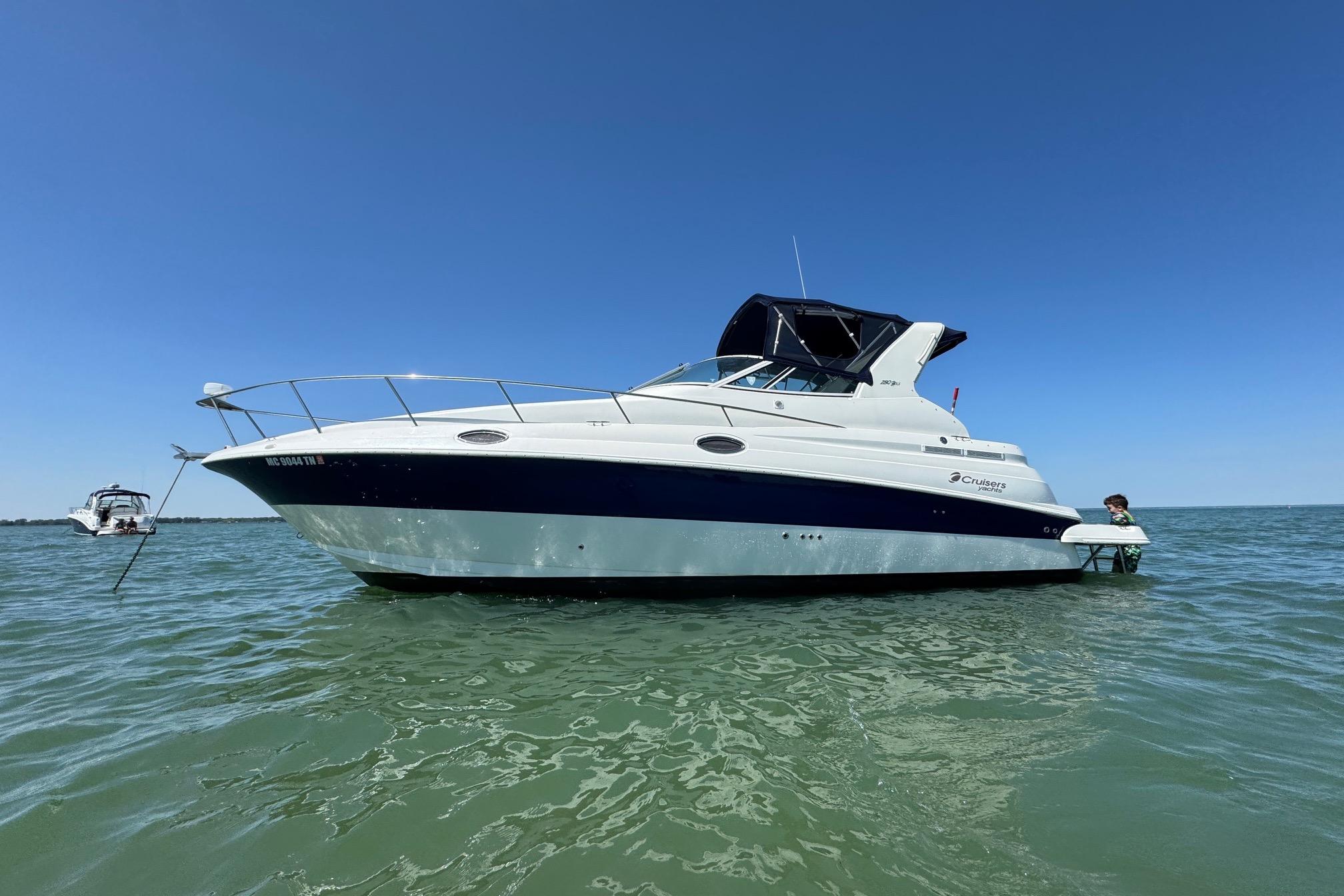 2004 Cruisers Yachts 280 CXi Express on calm water under clear blue sky.