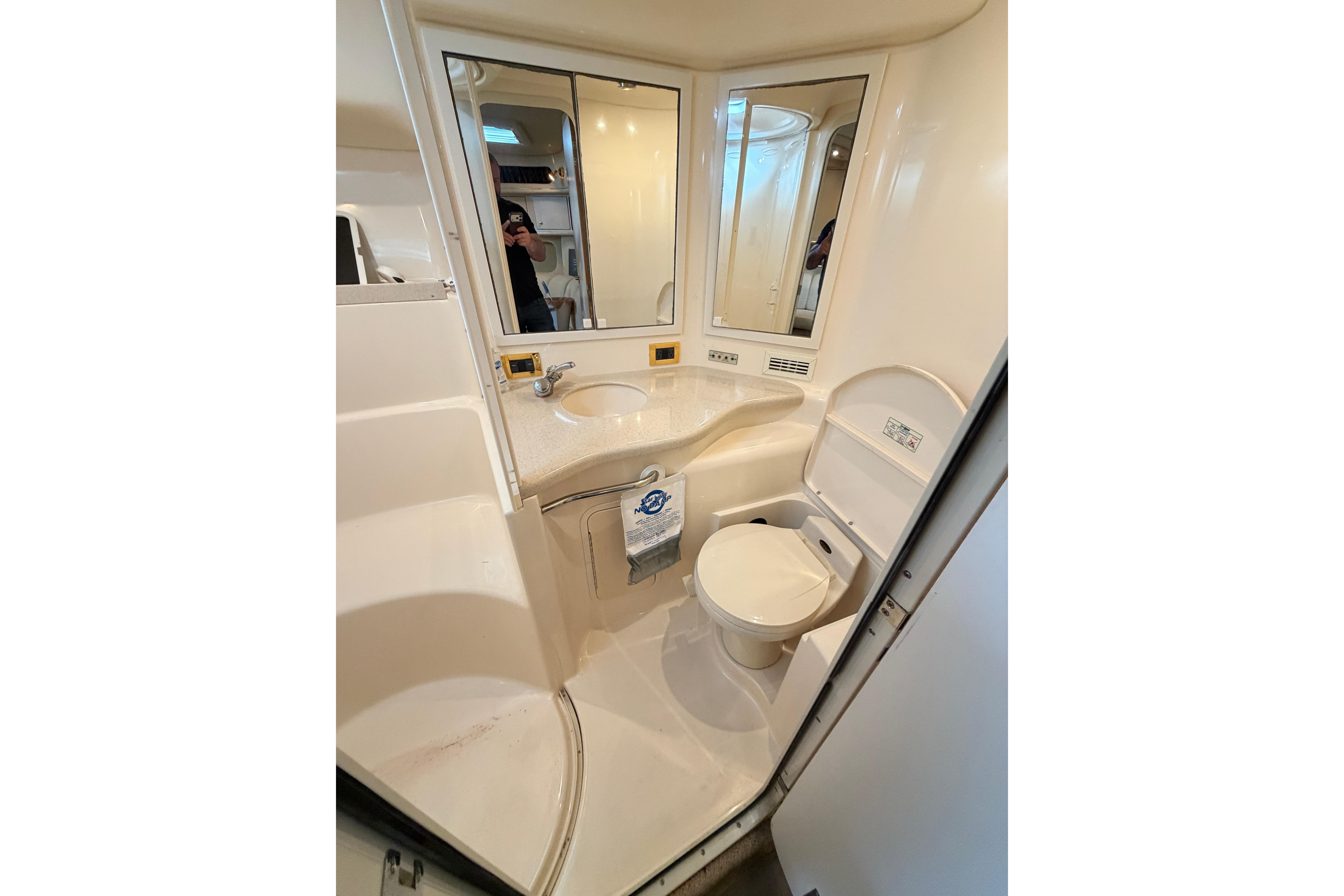 1999 Sea Ray 400 Sundancer bathroom with sink, toilet, and mirrors.