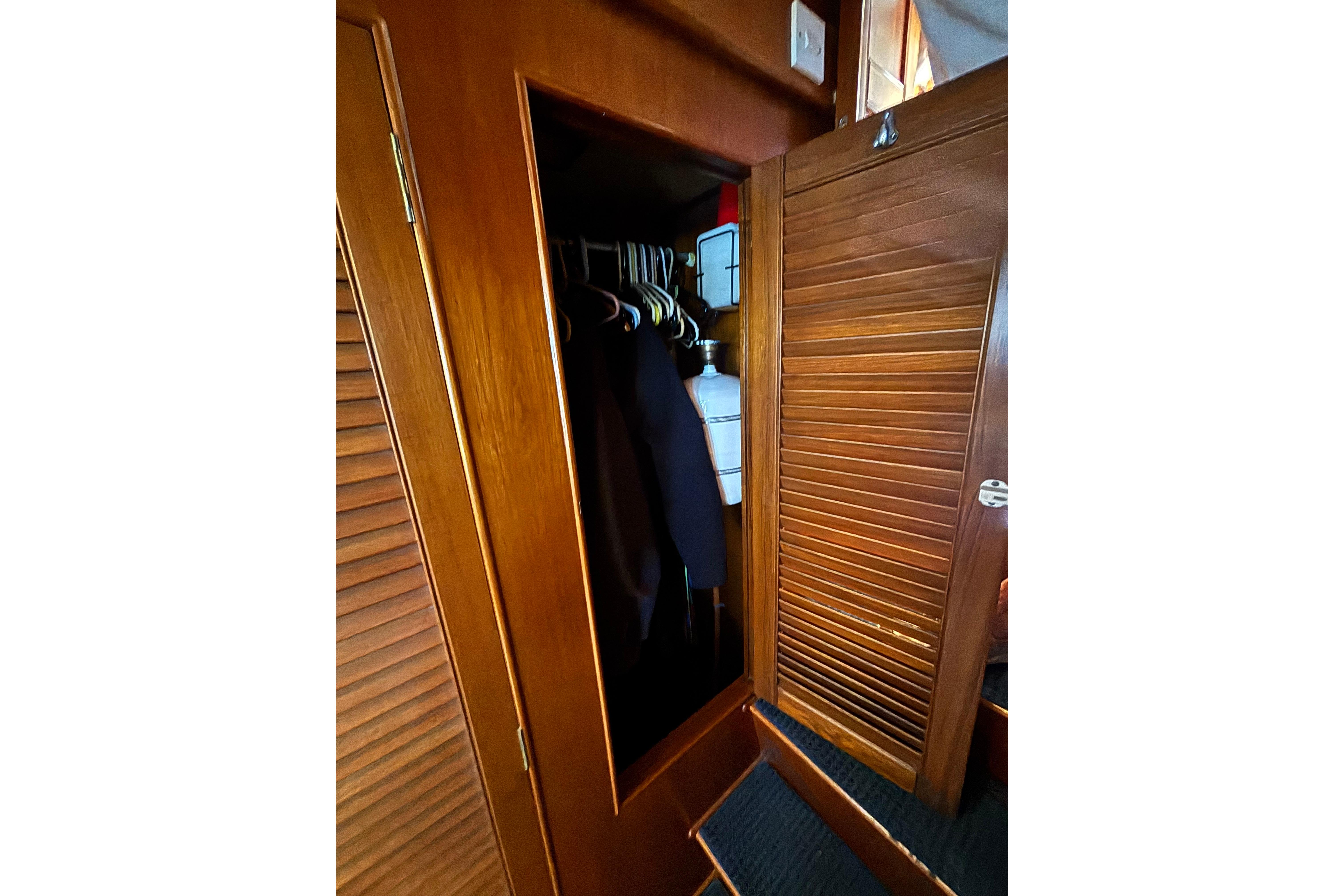 Wooden closet interior on 1989 Grand Banks 46 Classic yacht, with hanging clothes and storage.