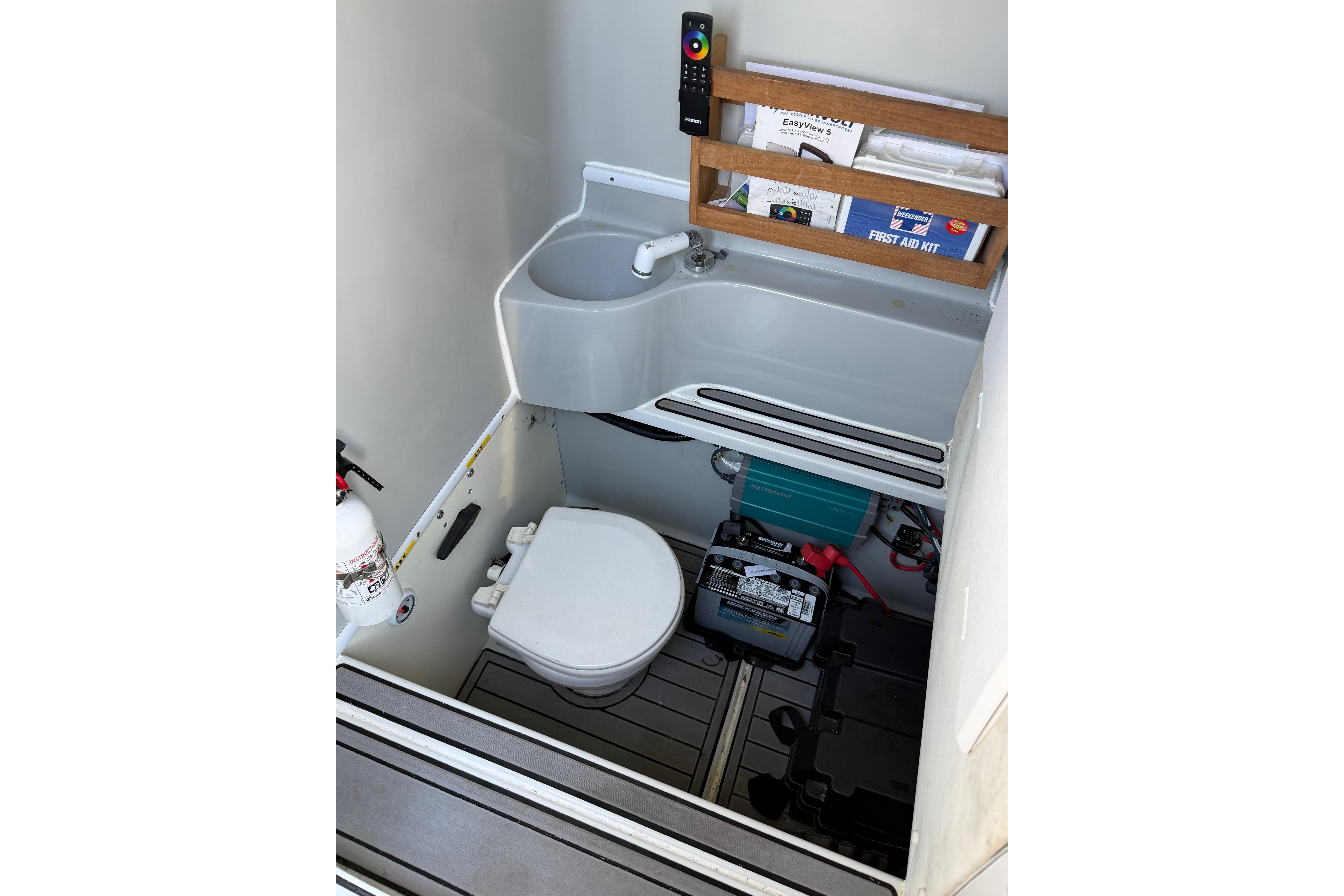 2015 Contender 32 ST boat interior with sink, toilet, and storage area.