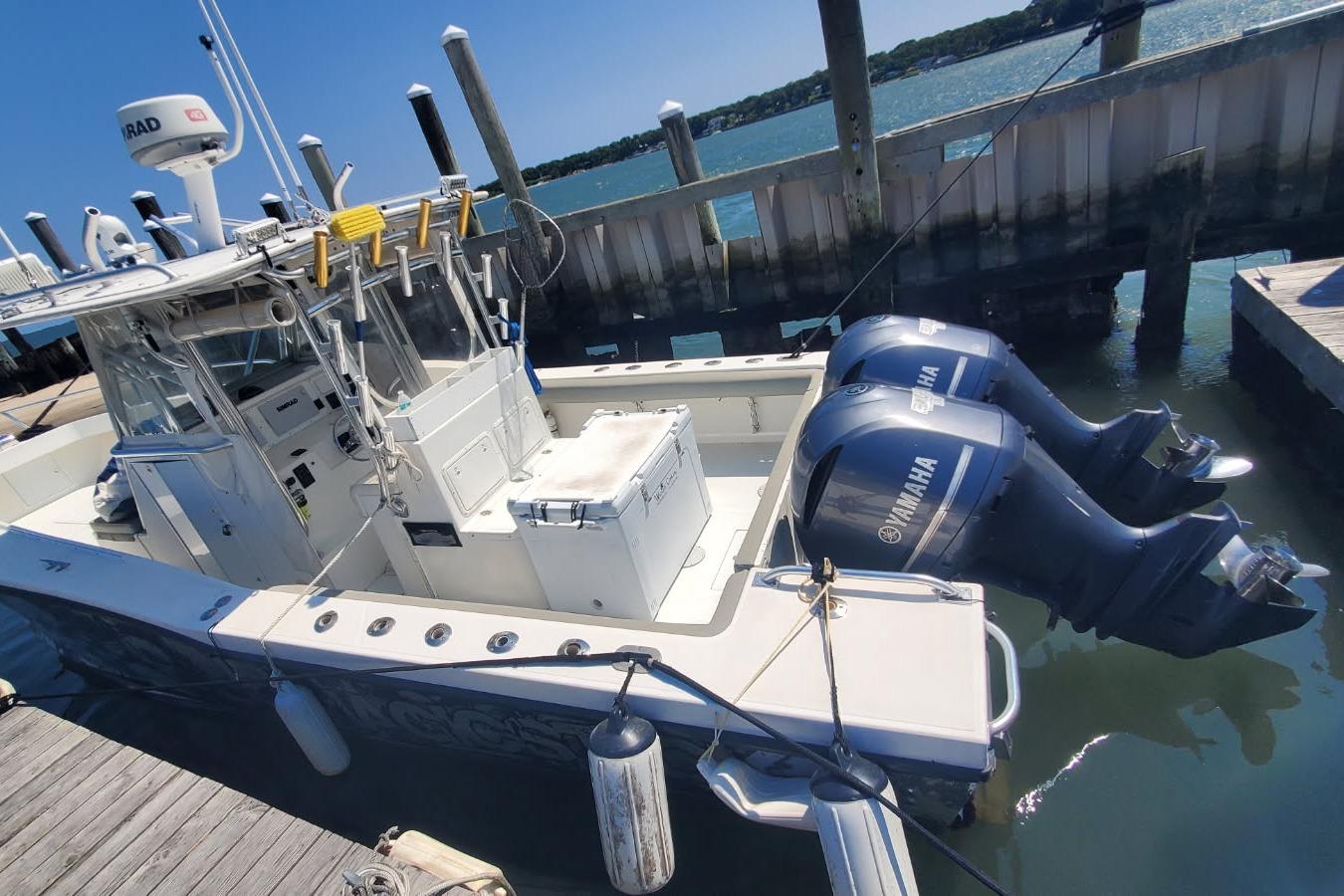 1998 Ocean Master 31 Center Console boat docked with twin Yamaha outboard engines.