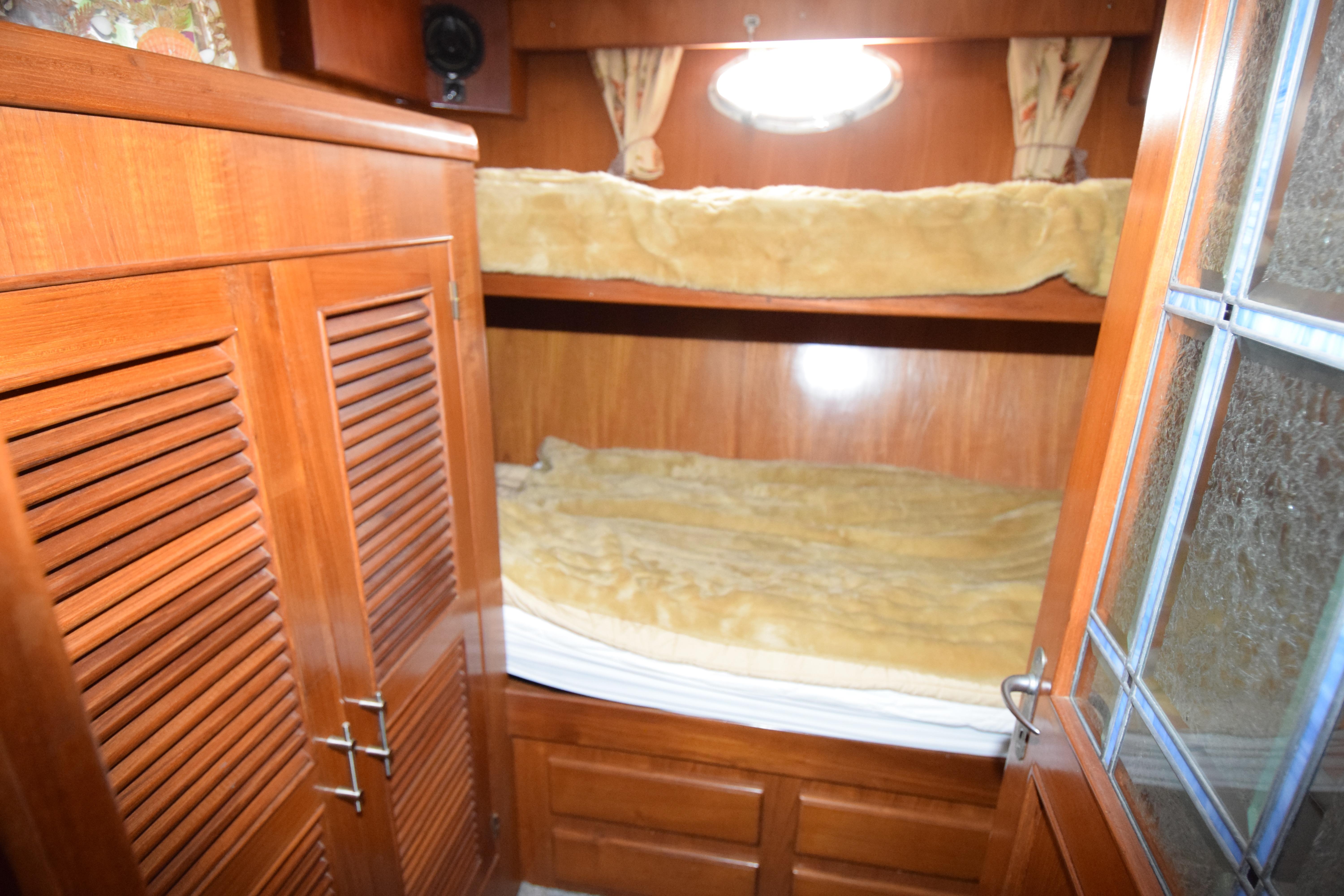 Interior of 1988 Sea Ranger 51 Motor Yacht with wooden bunk beds and storage.