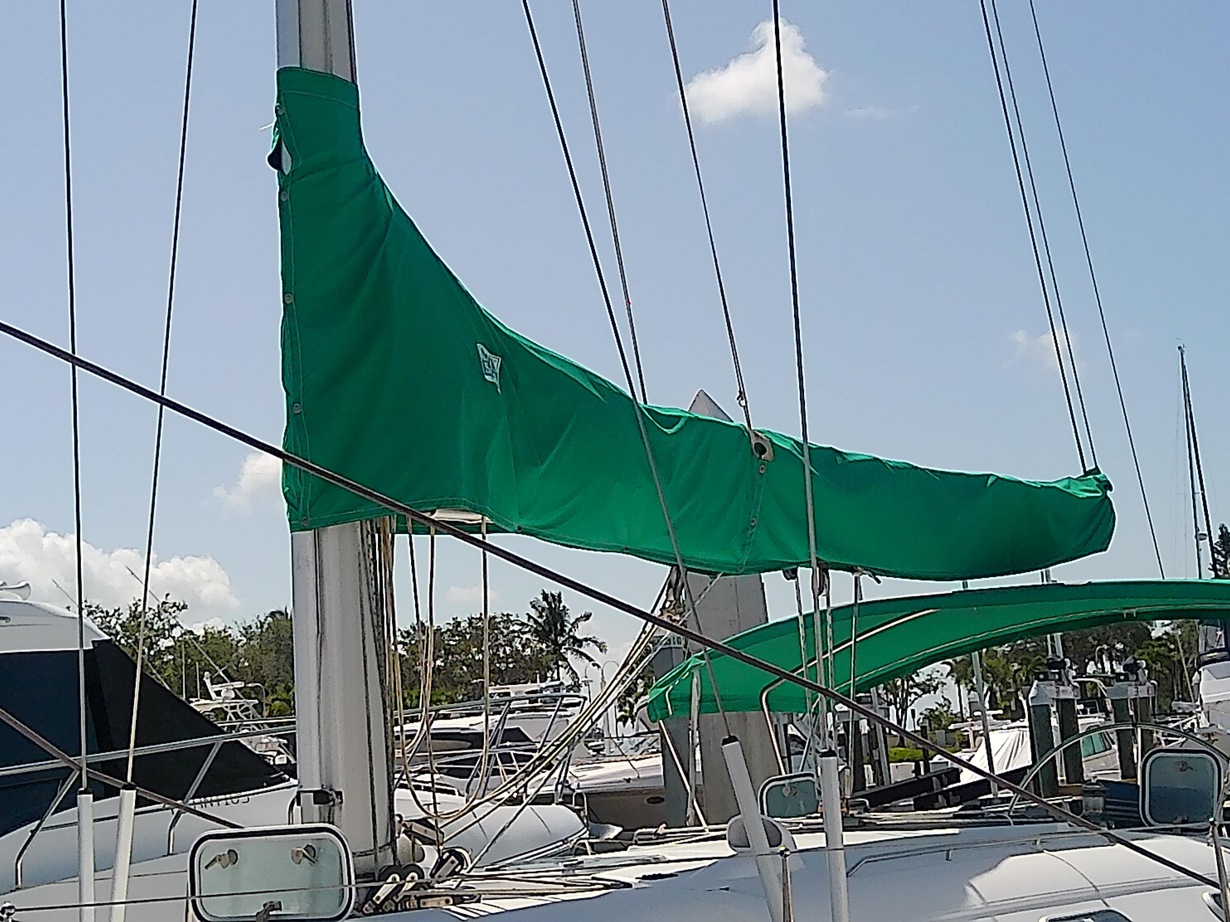 Sailboat Beneteau First 42s7, 1995 model, with green sail cover in marina.