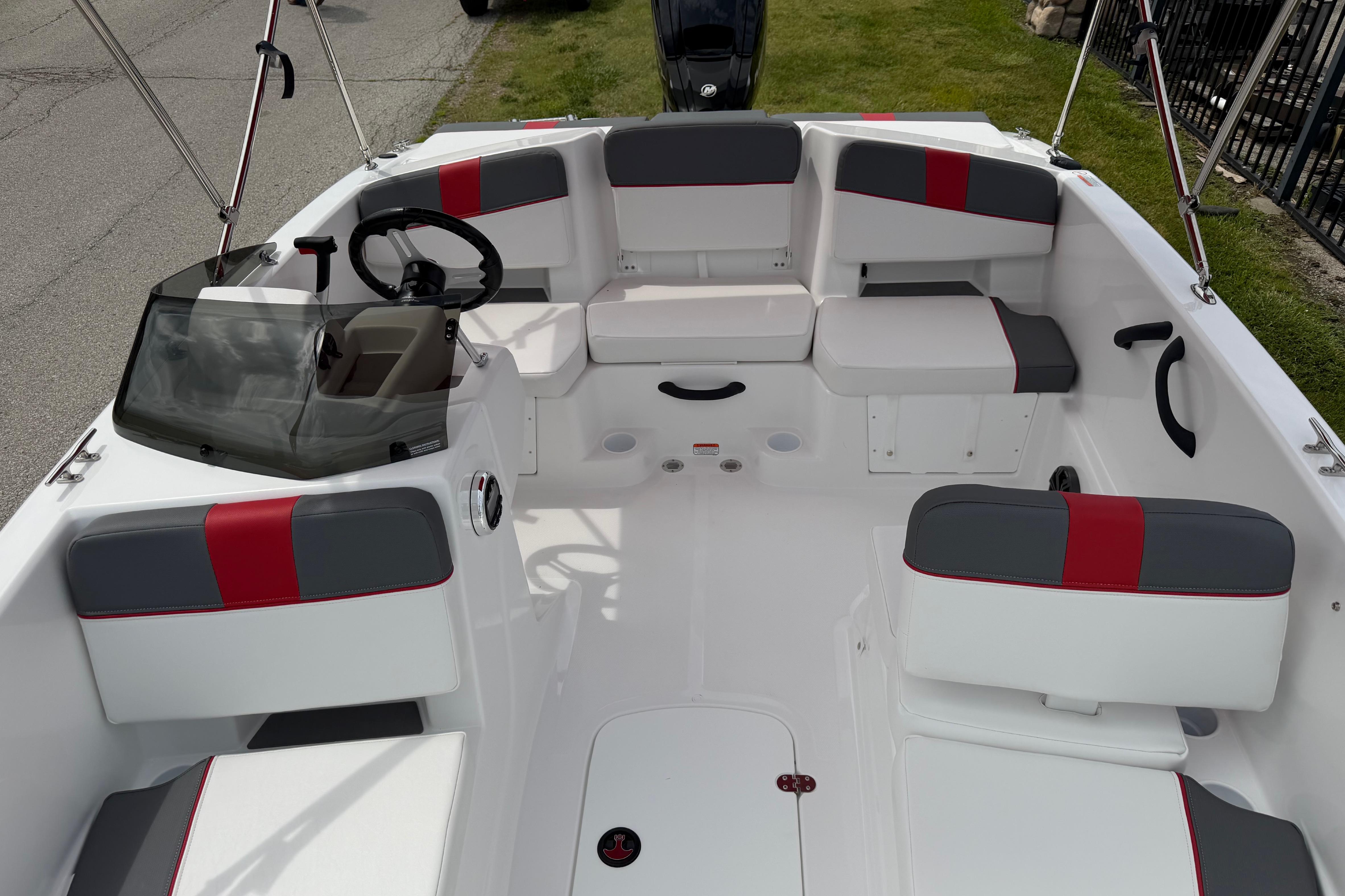 2026 Tahoe T18 boat interior with red and gray seating, steering wheel, and windshield.
