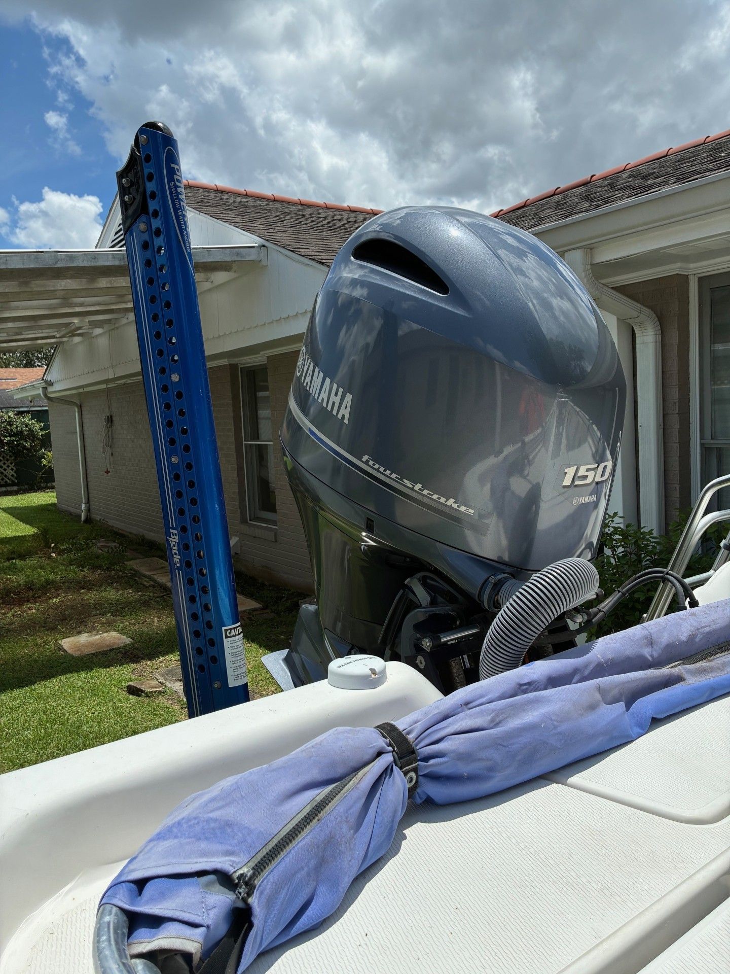 A Yamaha outboard motor on a boat parked next to a house.