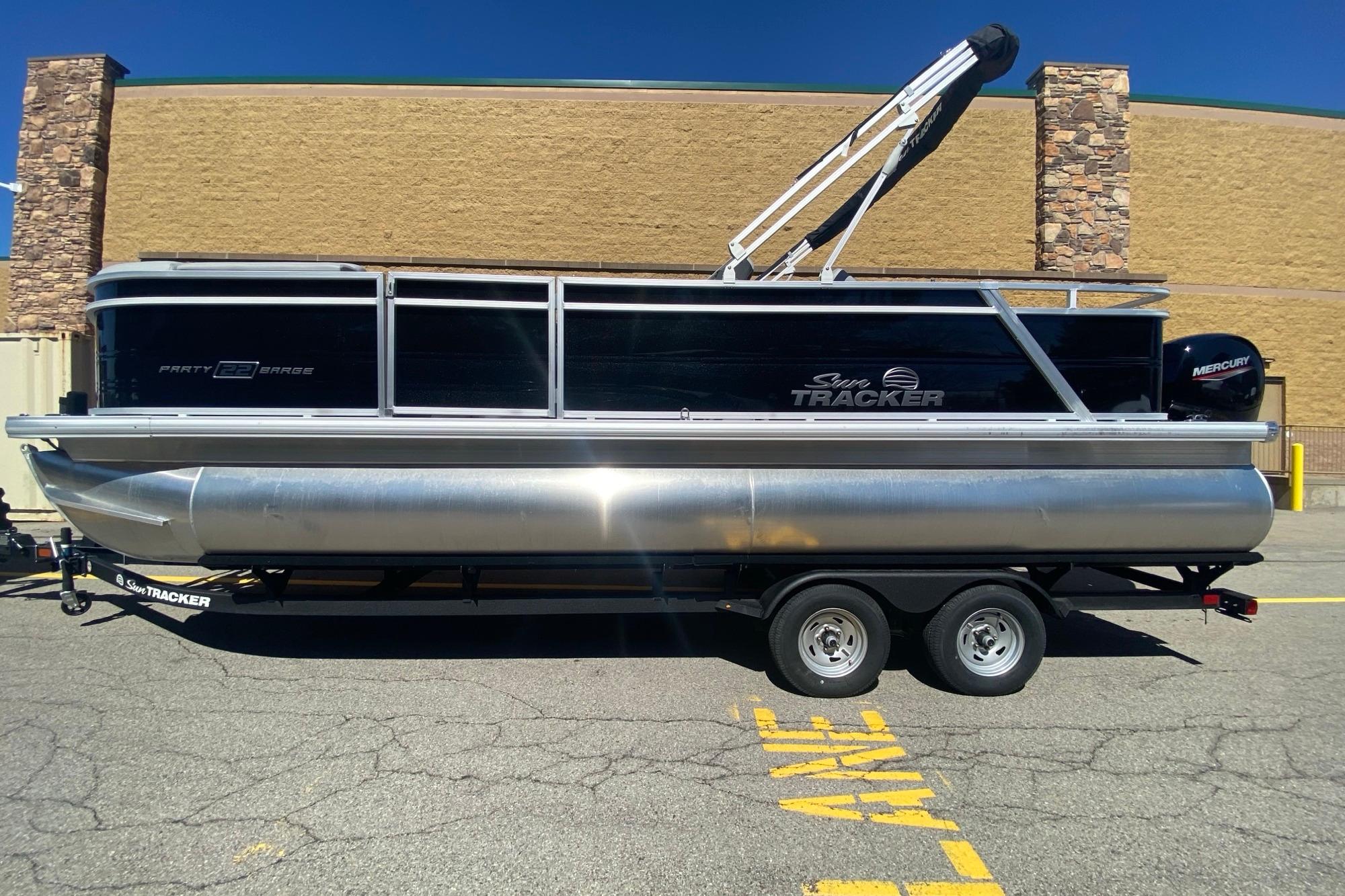 2026 Sun Tracker Party Barge 22 RF DLX pontoon boat on trailer, parked outdoors.