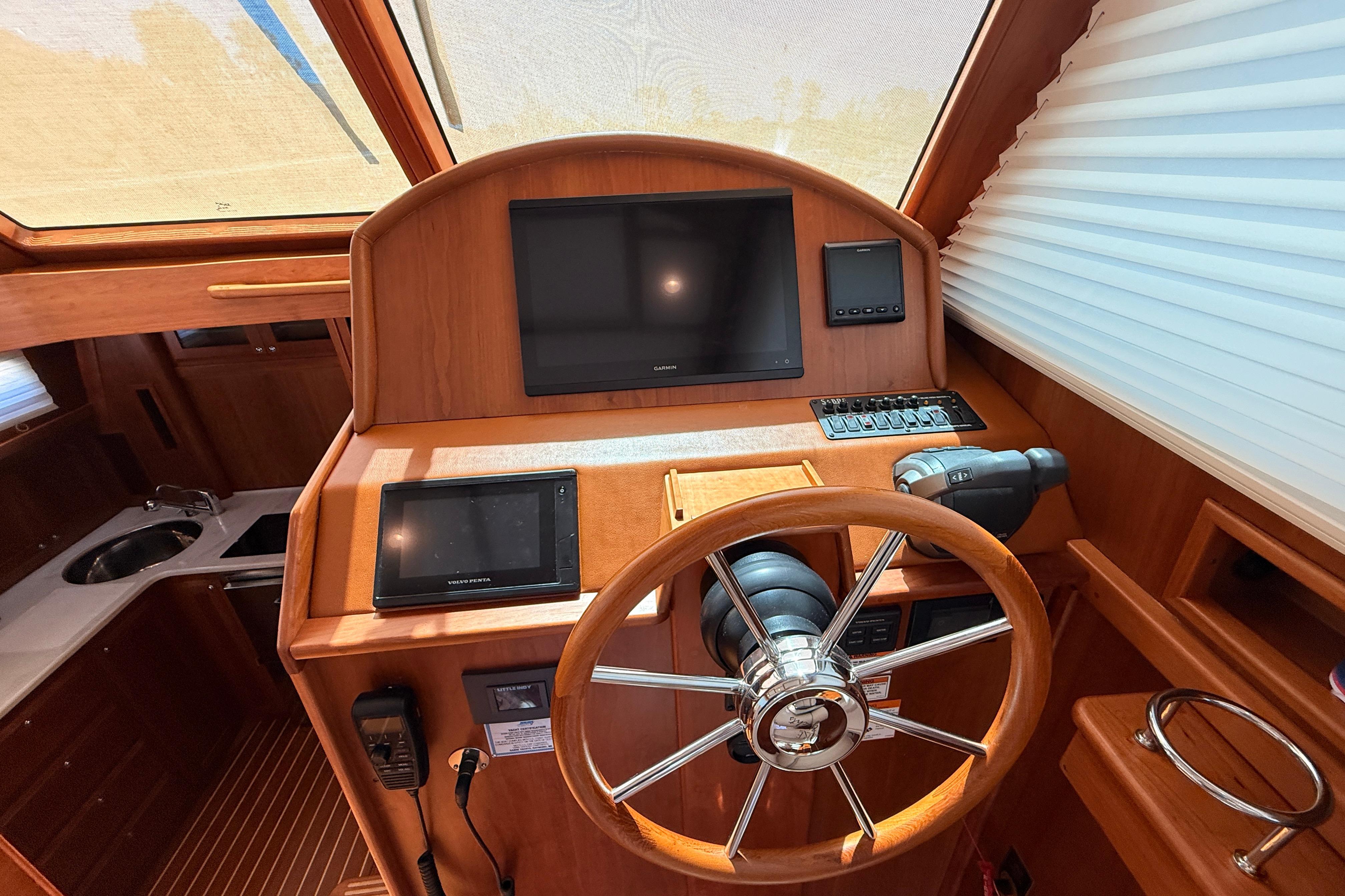 Helm of 2022 Sabre 38 Salon Express with modern navigation equipment and wooden finish.