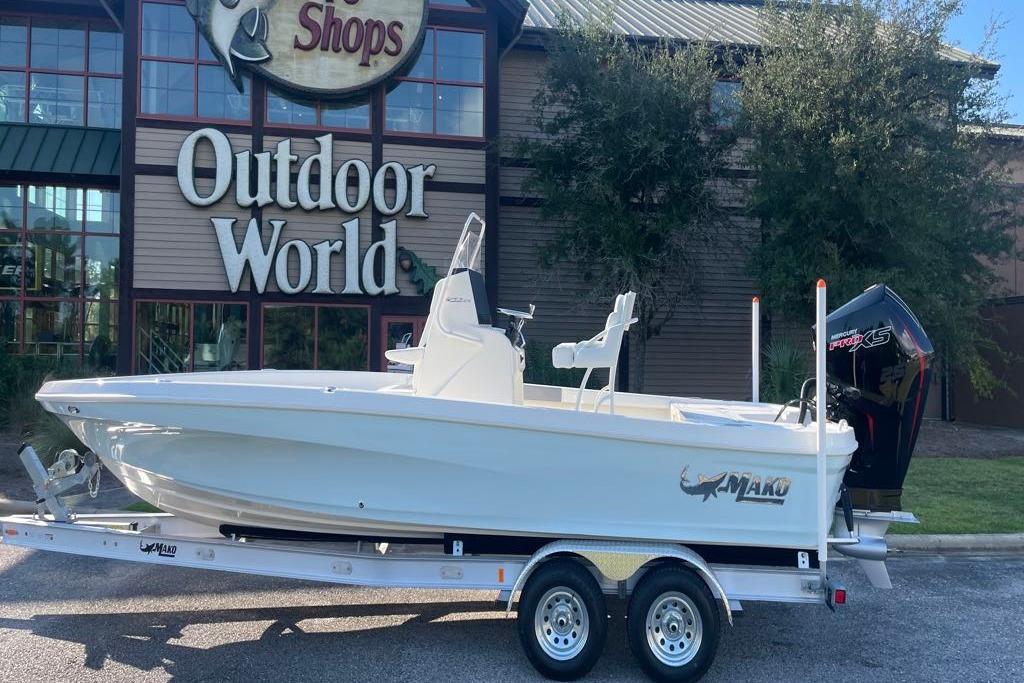 2026 Mako 24 APEX boat on trailer outside Outdoor World store.
