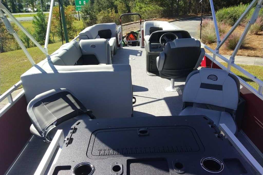 2026 Sun Tracker SportFish 22 DLX pontoon boat interior with seating and steering console.