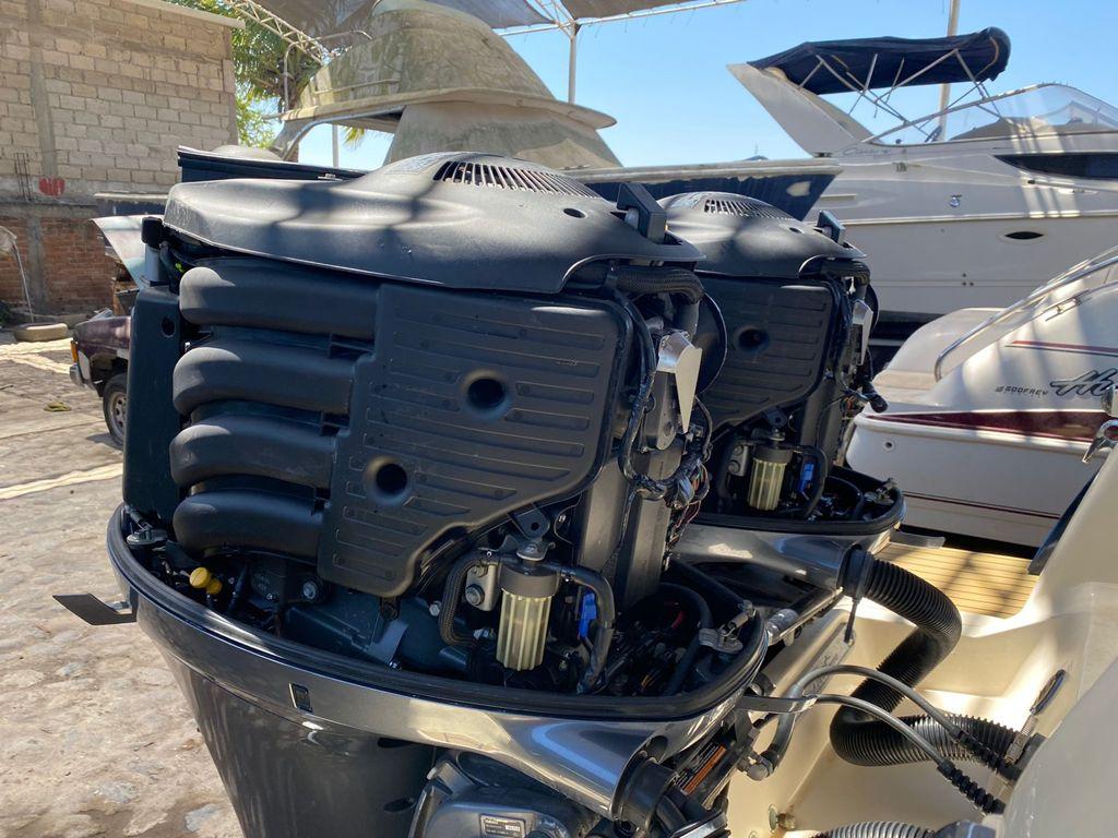 Twin outboard engines on a 2015 Scout 275 Dorado boat, docked in a marina.