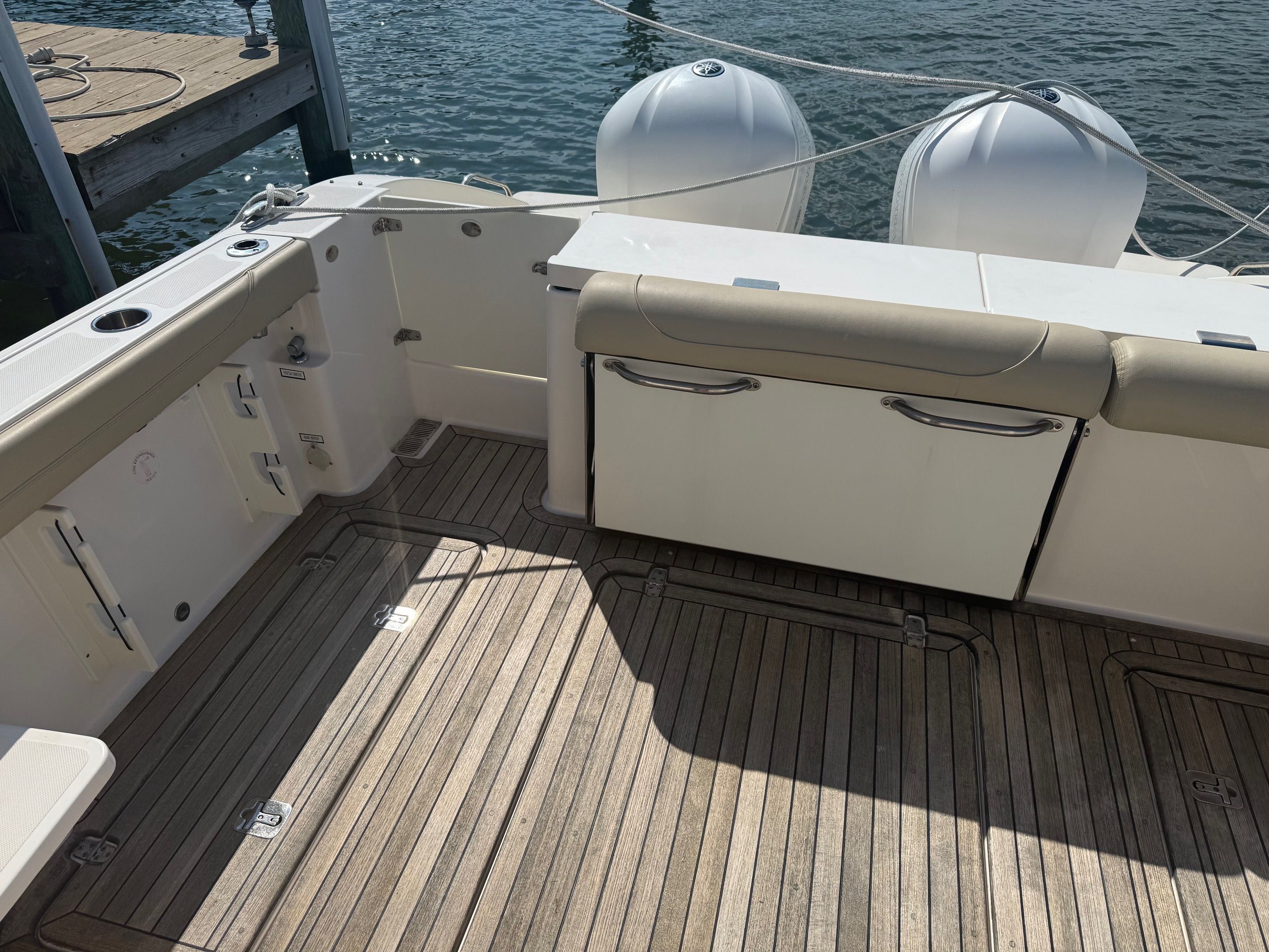 The image shows the stern of a 2016 Pursuit DC 325 Dual Console boat with twin engines.