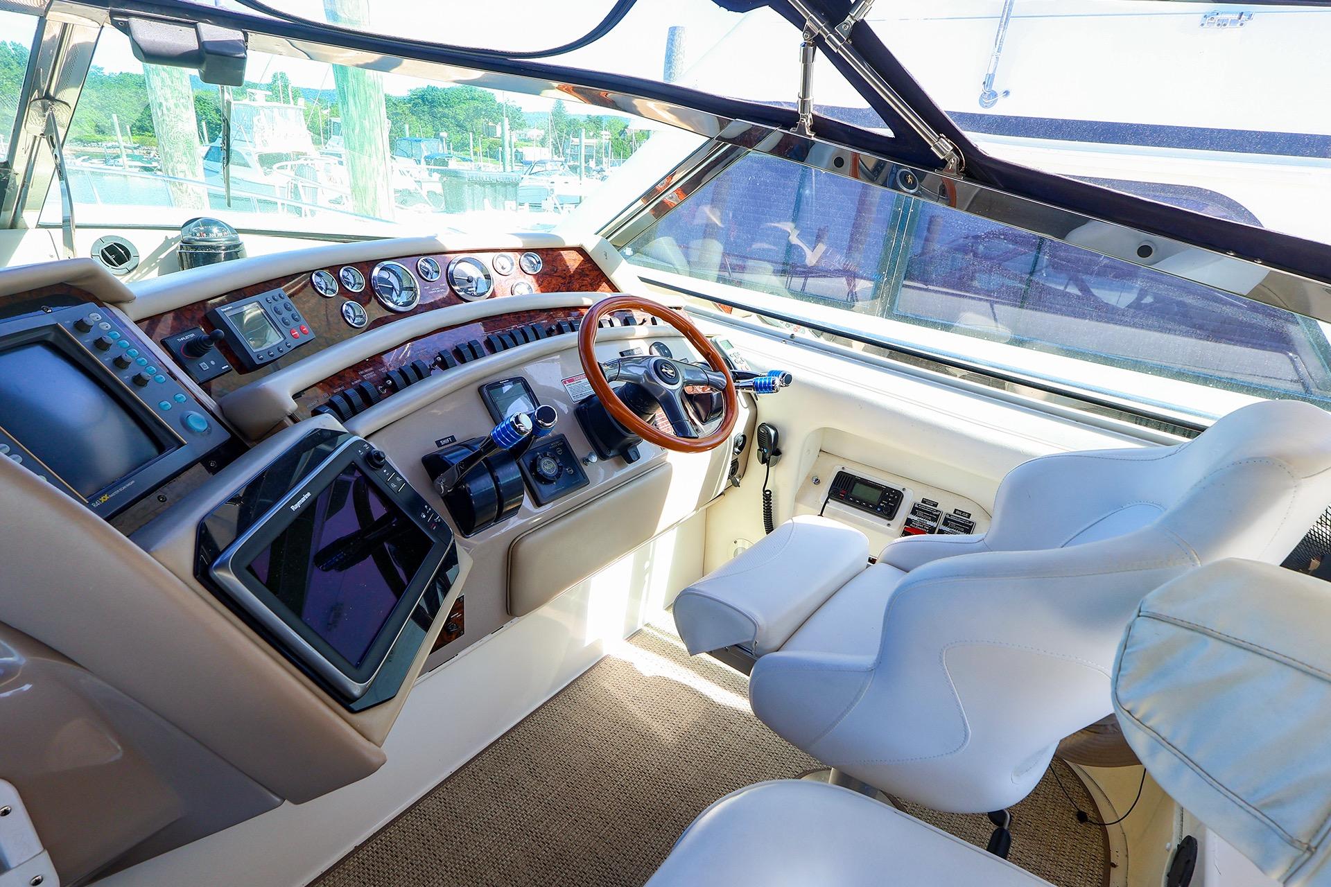 Cockpit of 1998 Sea Ray 500 Sundancer with modern navigation equipment and plush seating.