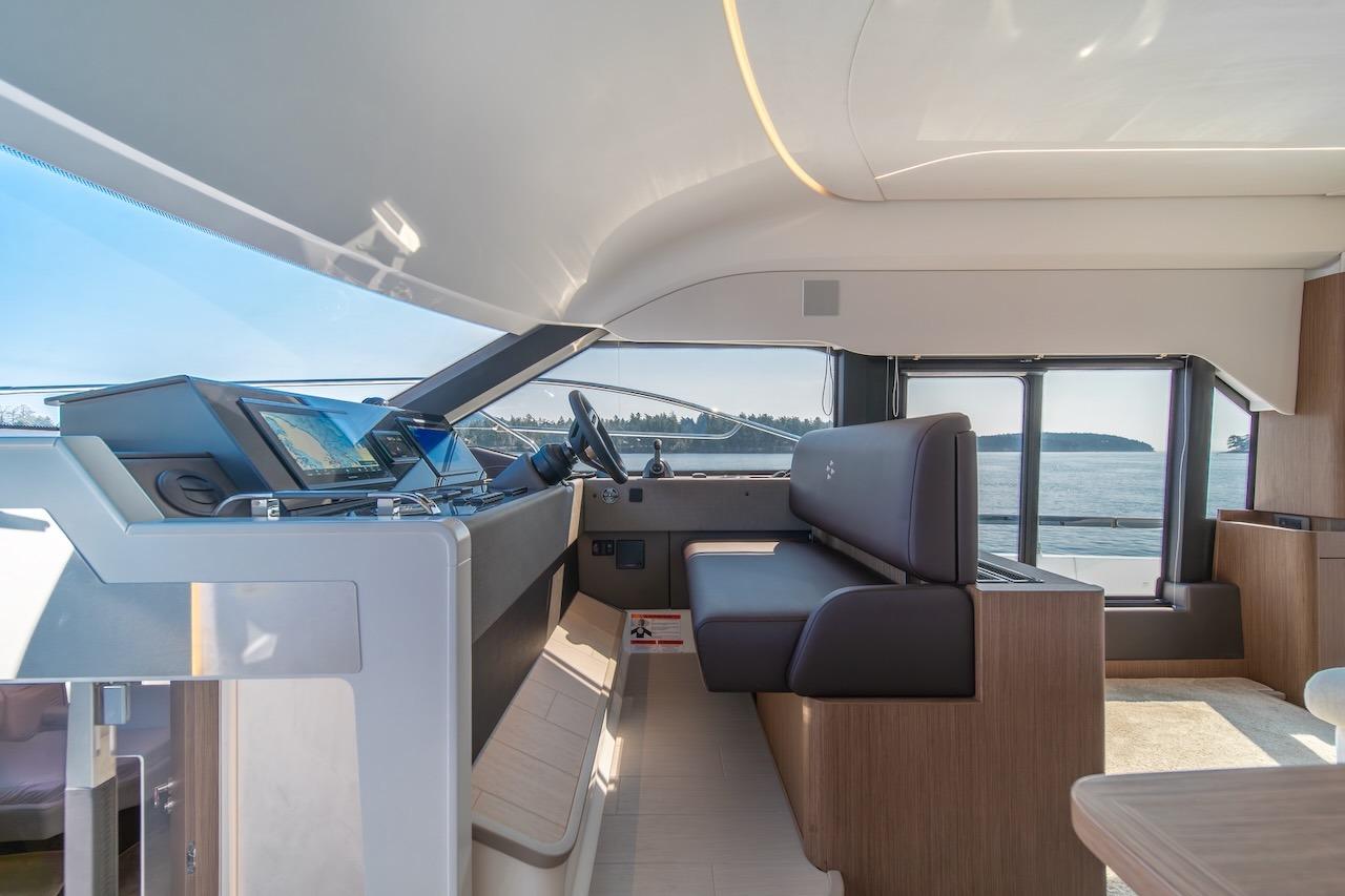 Luxurious interior of 2025 Prestige F4.9 yacht with modern helm and panoramic windows.