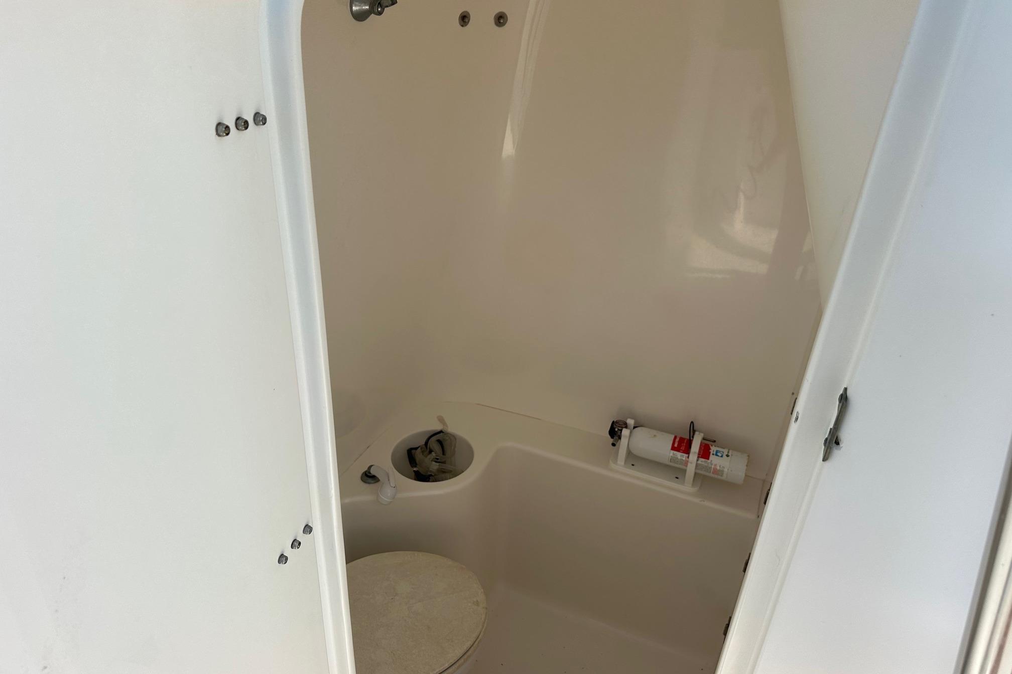 2003 Venture 34 Center Console boat interior with toilet and fire extinguisher.