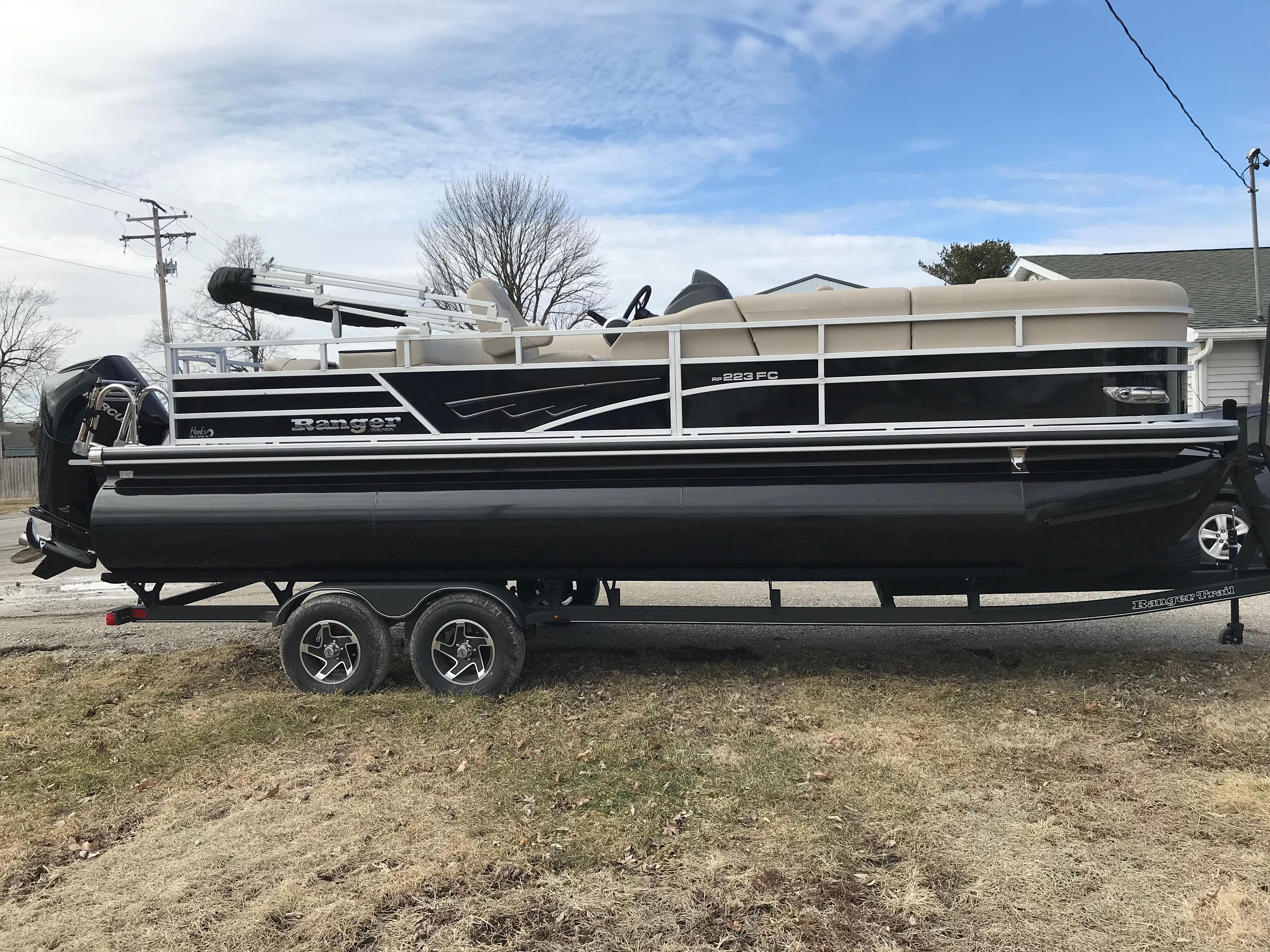 2025 Ranger Reata 223FC pontoon boat on trailer, parked outdoors.